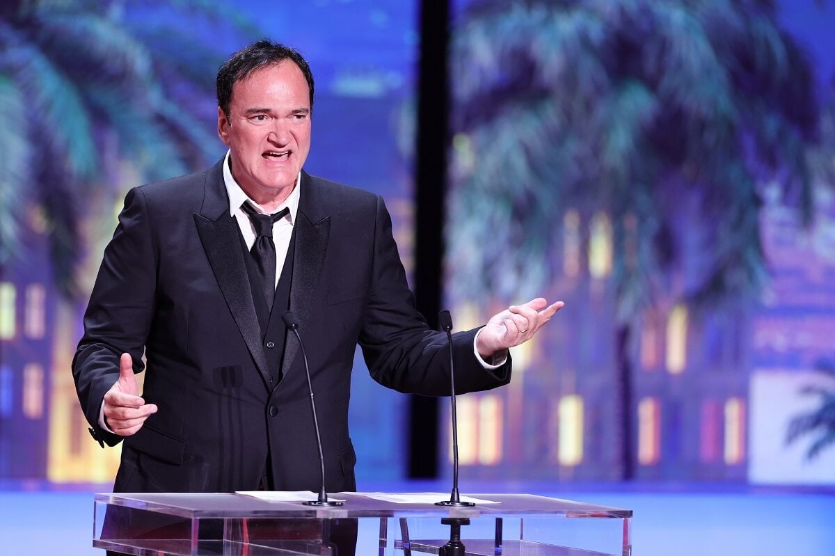 Quentin Tarantino presenting at The Grand Prix Award while wearing a suit.