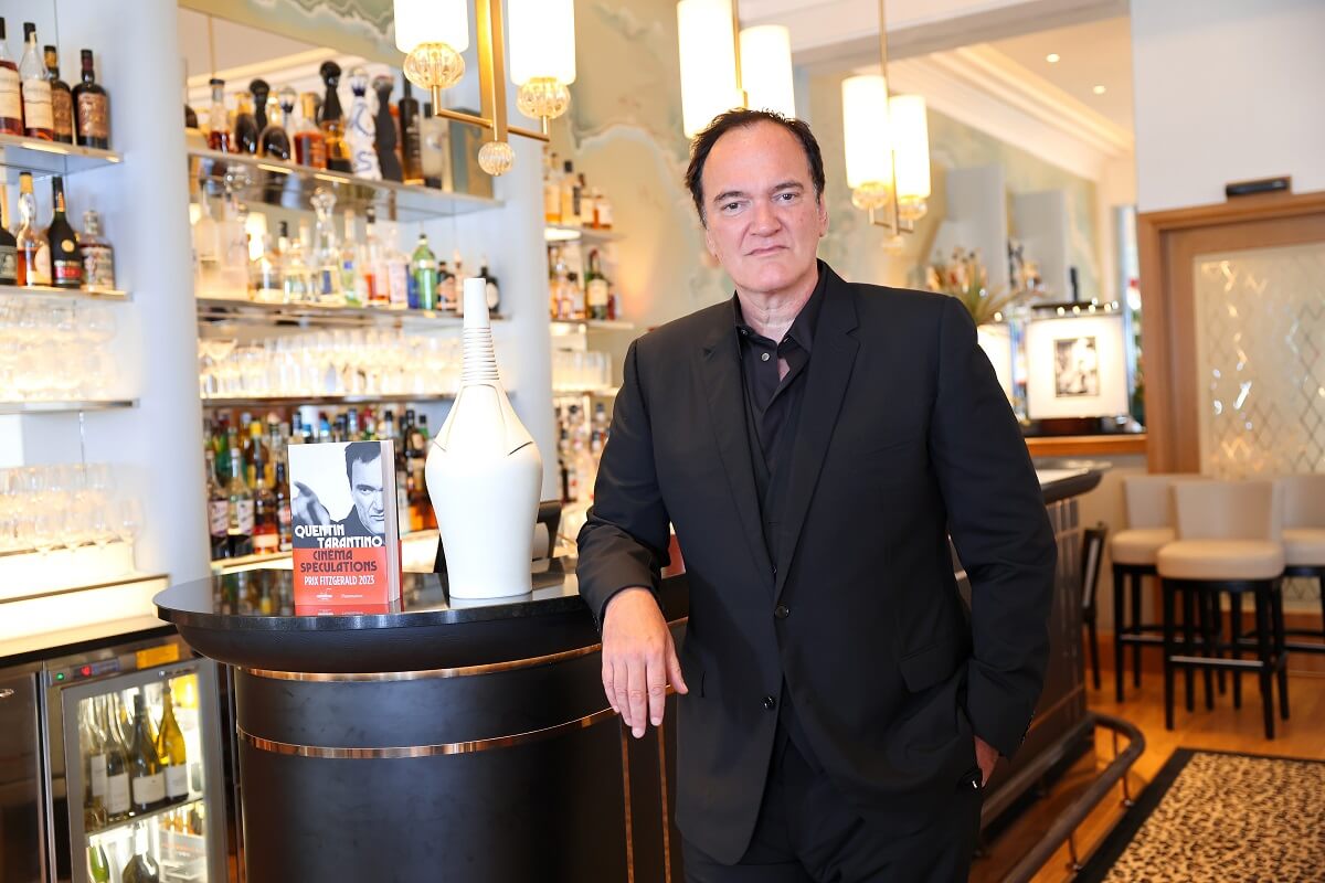 Quentin Tarantino posing at the Hotel Belles Rives next to his book.