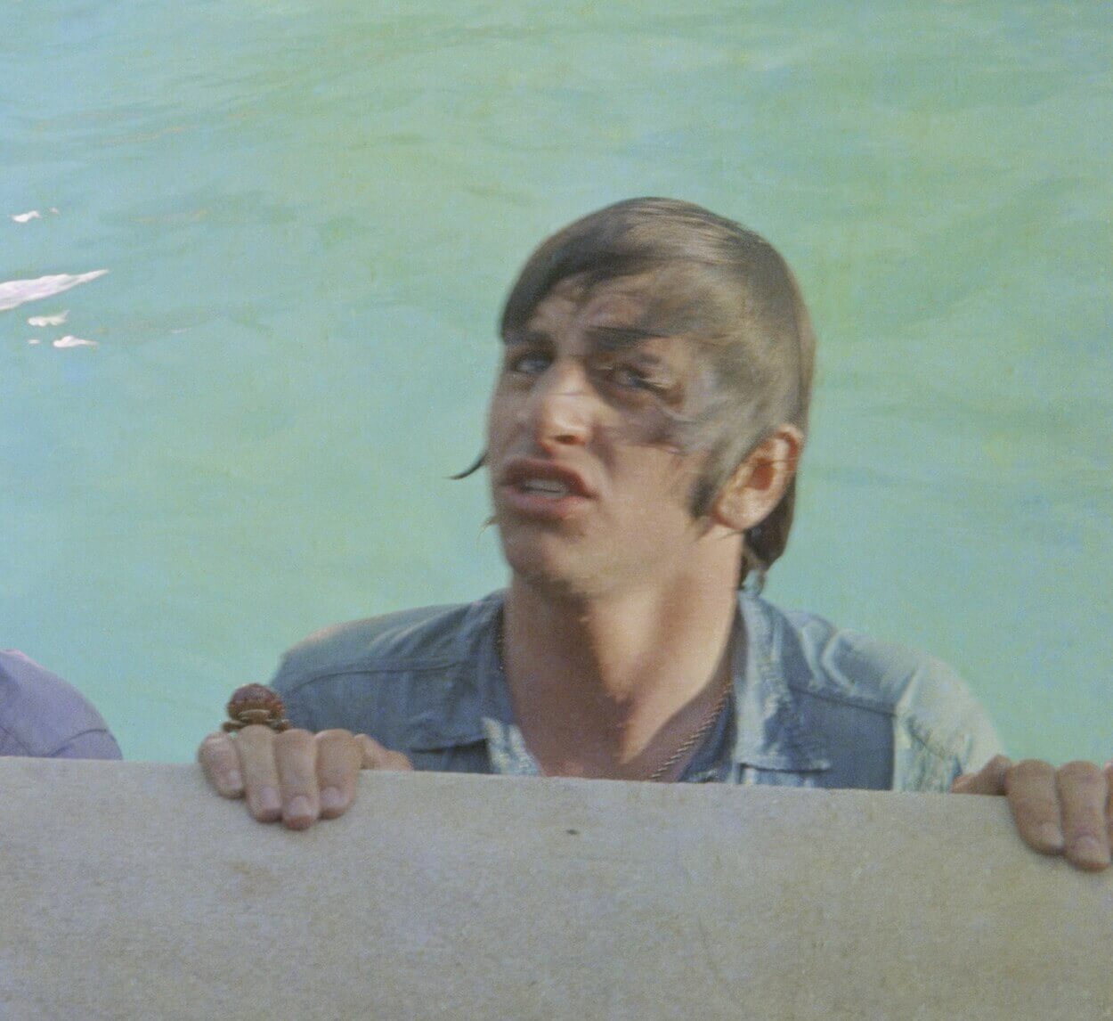 A Ringo Starr climbing out of a swimming pool while filming The Beatles' movie 'Help!' in the Bahamas in 1965.