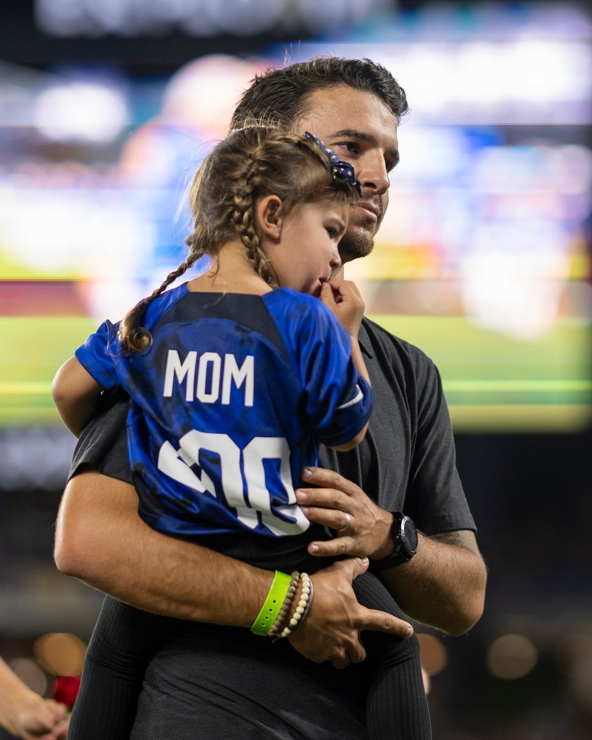 Servando Carrasco holds daughter Charlie Elena Carrasco after attending his wife, Alex Morgan's 200th CAP ceremony