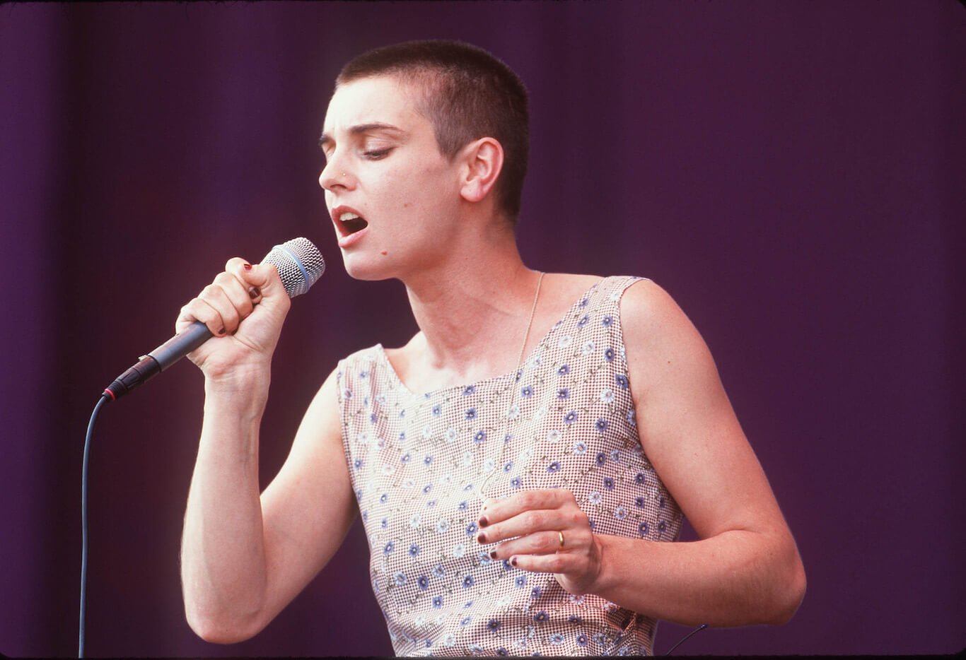 A young Sinead O'Connor singing into a microphone