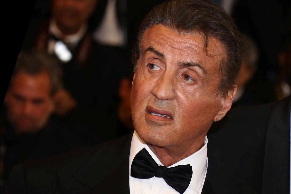 Sylvester Stallone taking a picture in a suit at the premiere of 'Rambo - Last Blood'.
