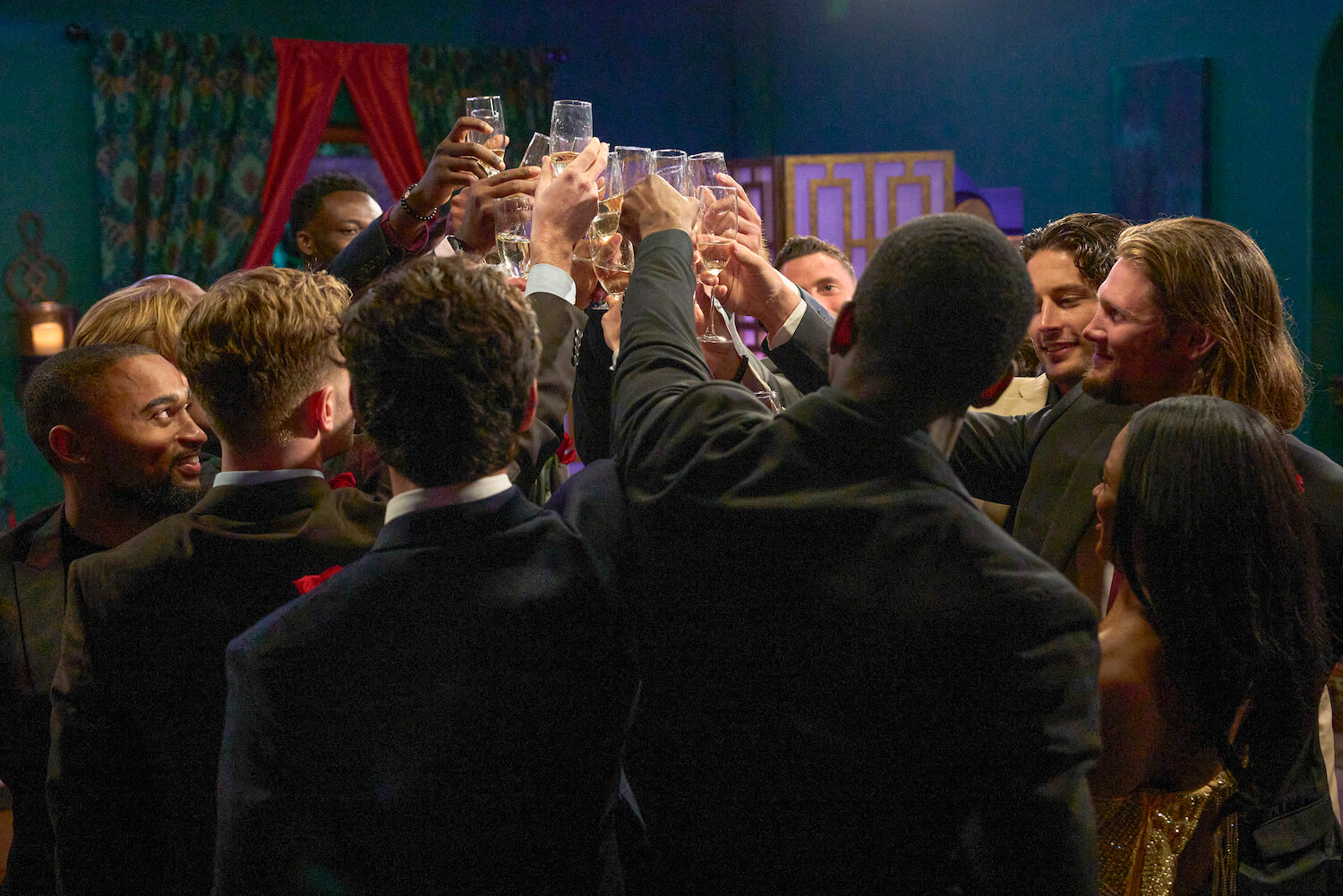 'The Bachelorette' 2023 cast members toasting with their arms raised holding glasses