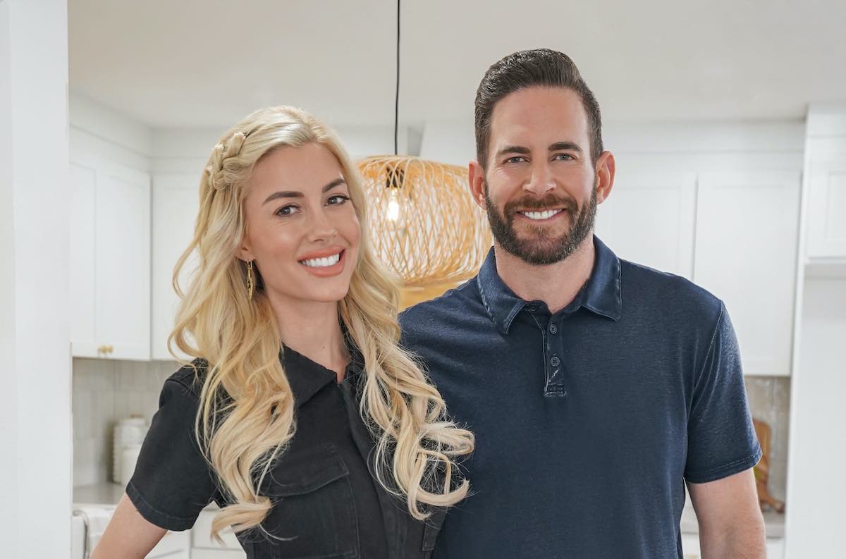 Heather El Moussa, dressed in black, standing next to Tarek El Moussa in publicity shot for 'The Flipping El Moussas' Season 2