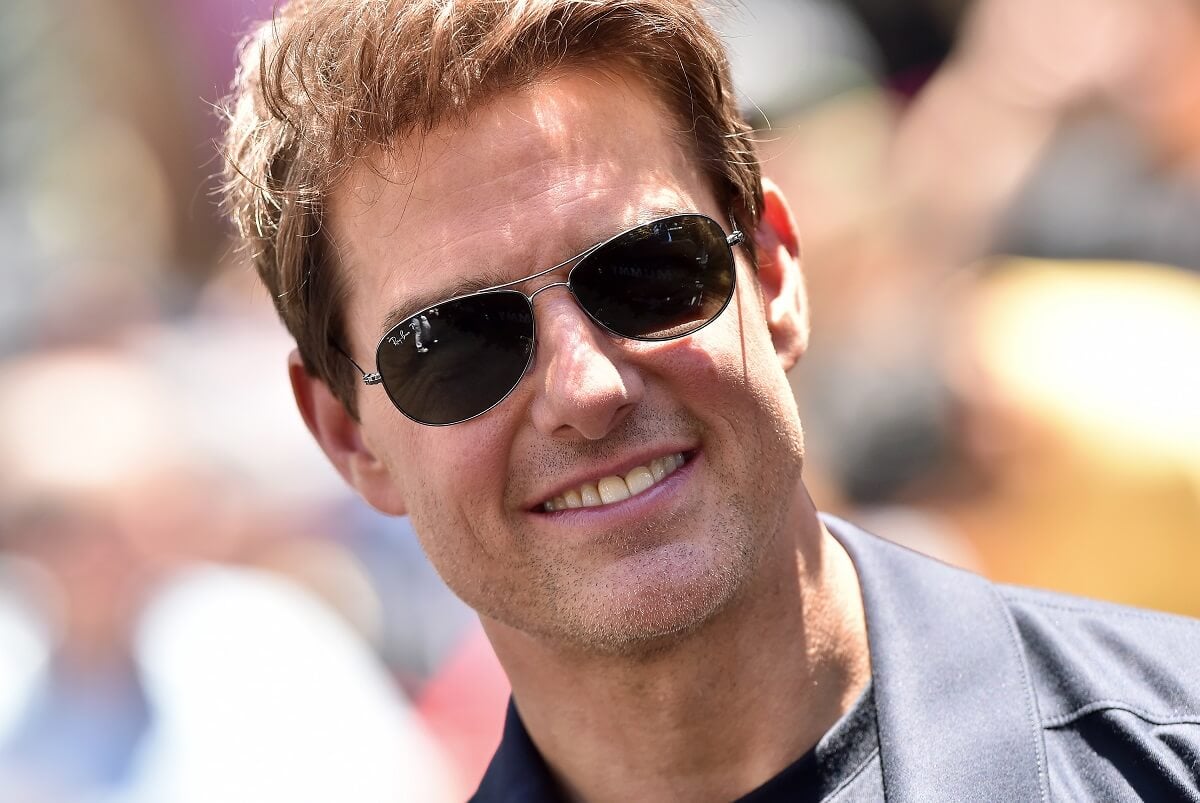 Tom Cruise taking a picture while smiling at The Mummy Day event.