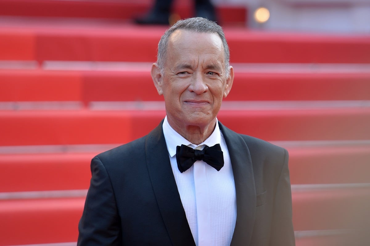 Tom Hanks wearing a suit and bowtie while taking a picture at the world premiere of 'Amsterdam'.