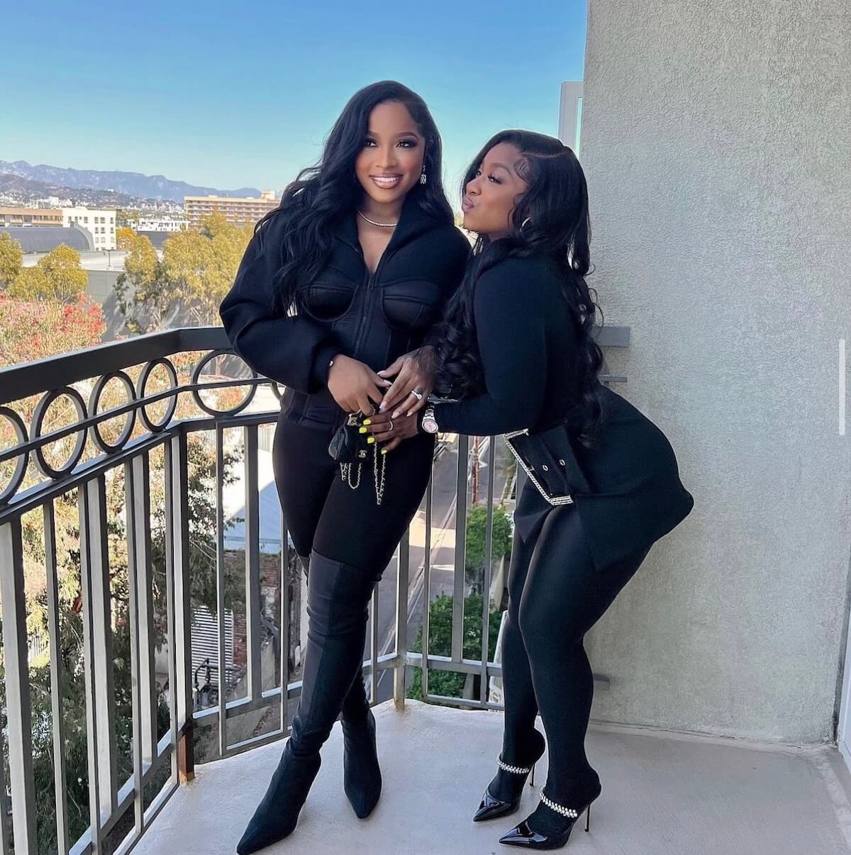 Toya Johnson-Rushing and Reginae Carter dressed in black and posing on a balcony