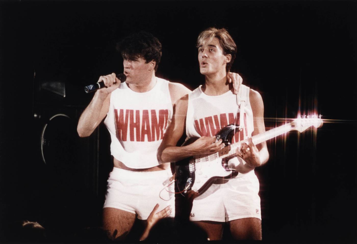 George Michael and Andrew Ridgeley perform in Wham t-shirts 
