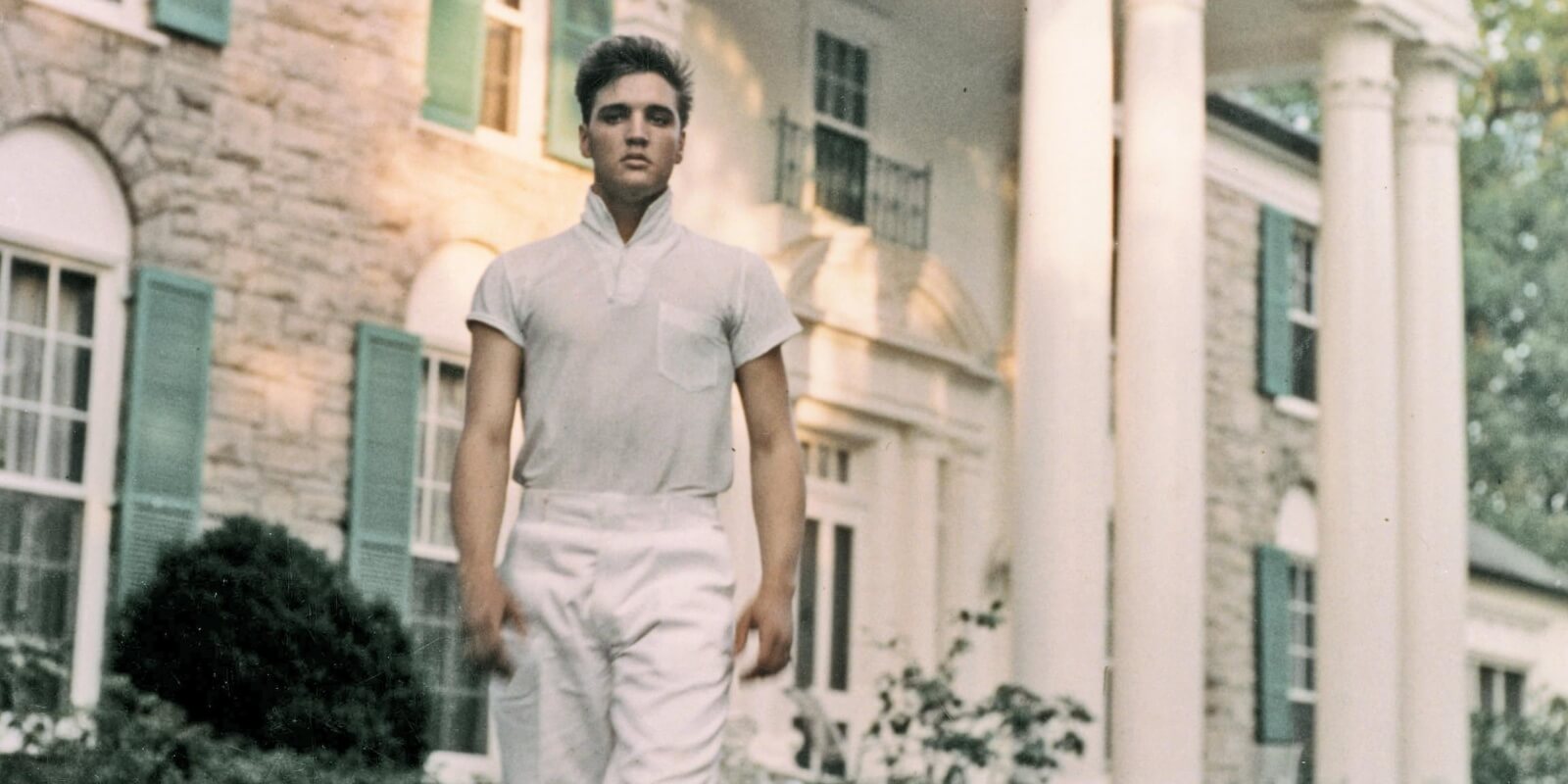 Elvis Presley stands in front at Graceland in Memphis, TN.