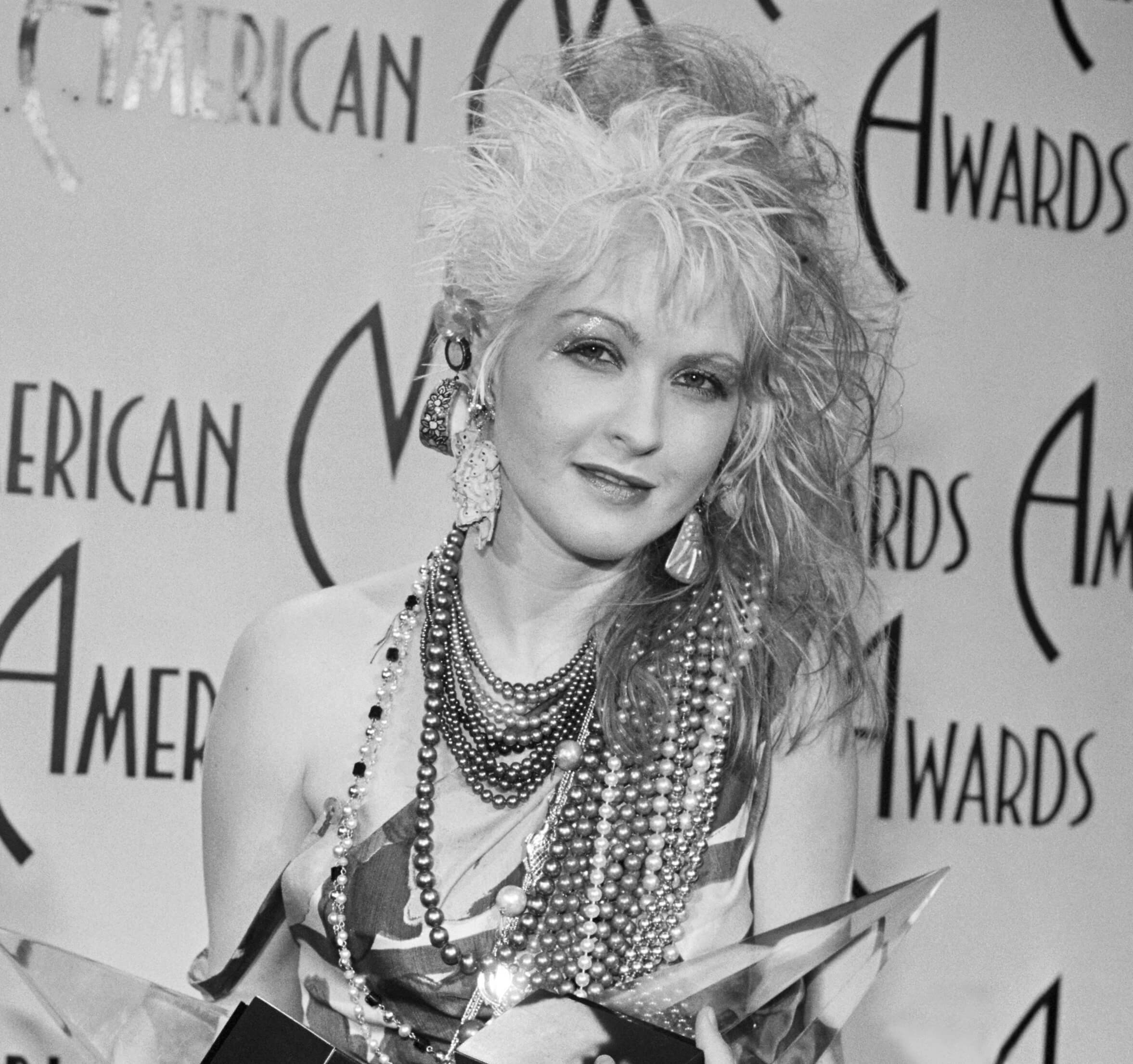 Cyndi Lauper holding awards