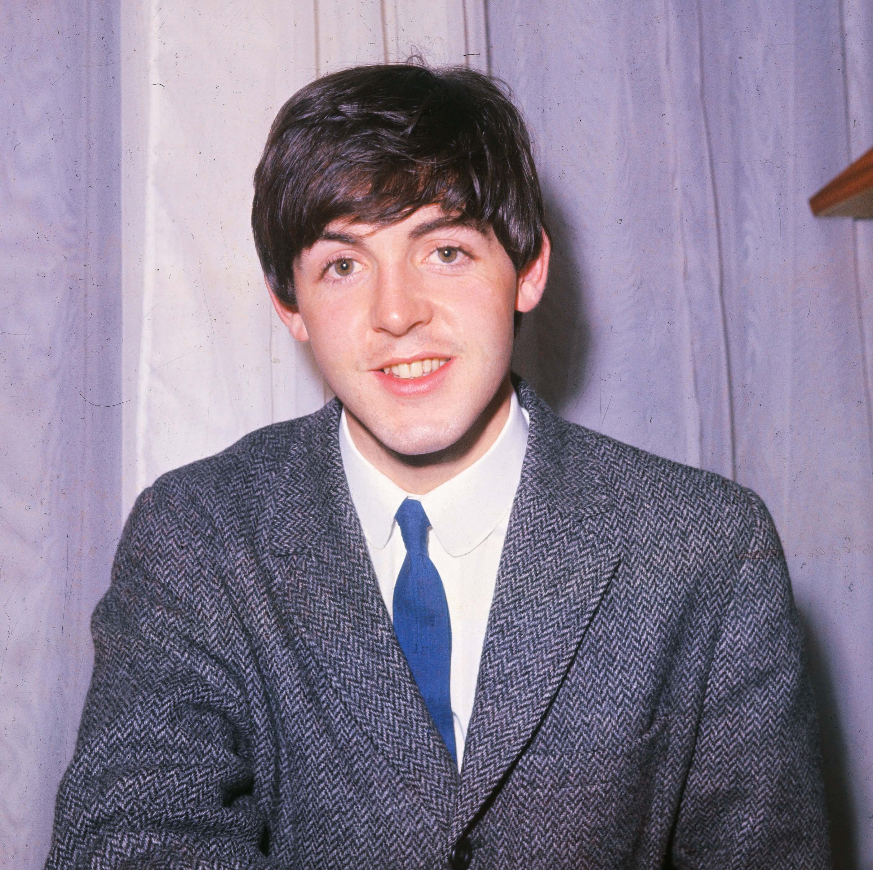 The Beatles' Paul McCartney in front of a curtain