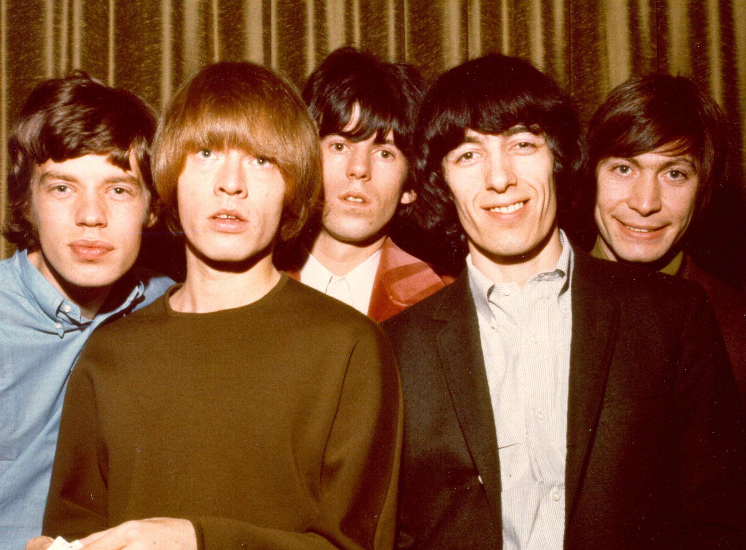 The Rolling Stones in front of a curtain