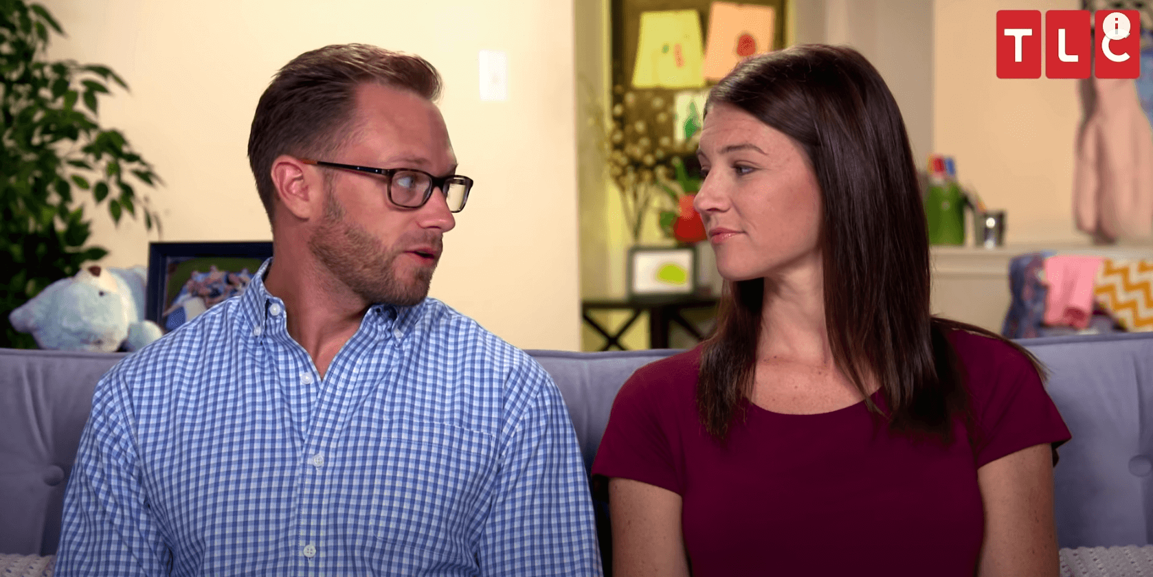 'OutDaughtered' stars Adam and Danielle Busby looking at each other while sitting in their house