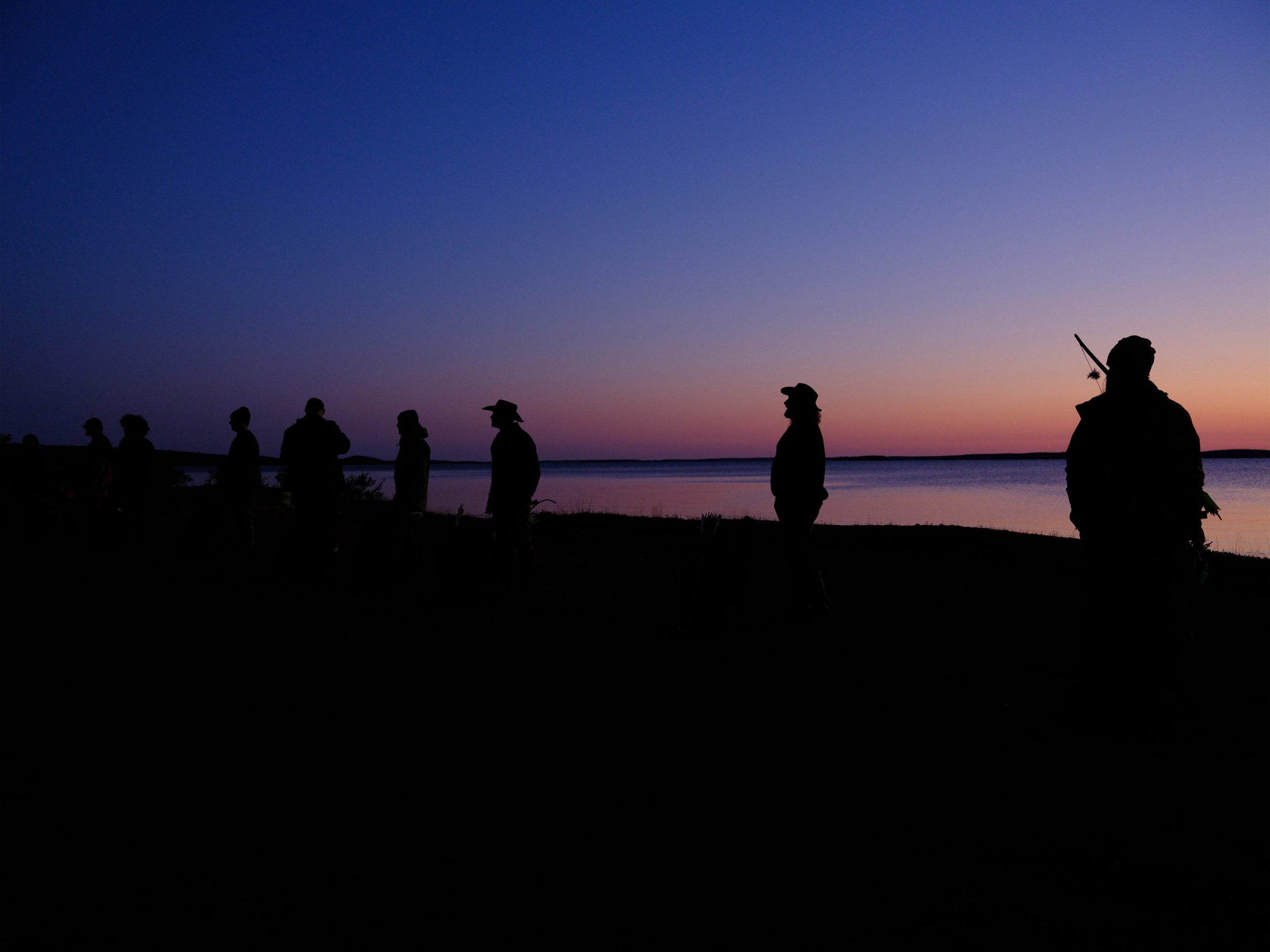 The 'Alone' Season 10 cast silhouetted against a sky at dusk