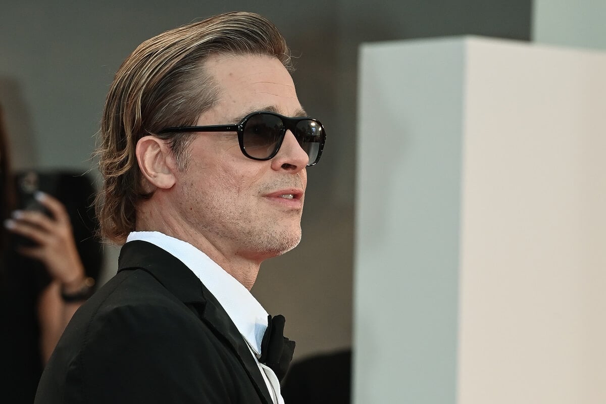 Brad Pitt attending the 79th Venice International Film Festival while wearing a suit and sunglasses.