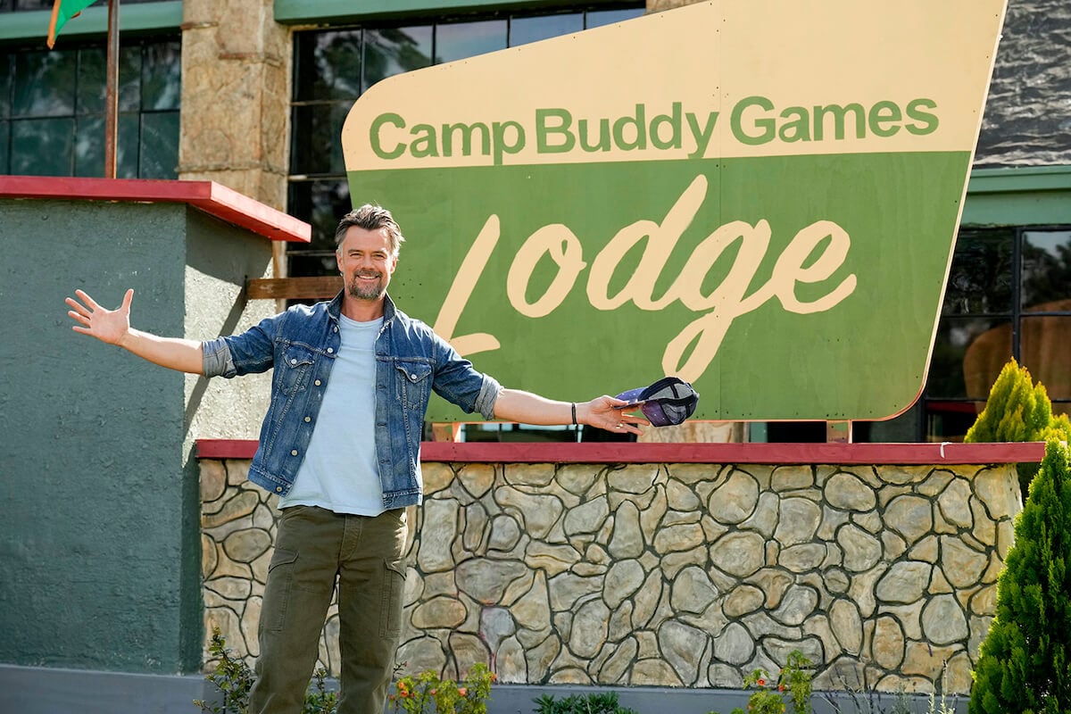 'Buddy Games' host Josh Duhamel standing in front of 'Camp Buddy Game Lodge' sign