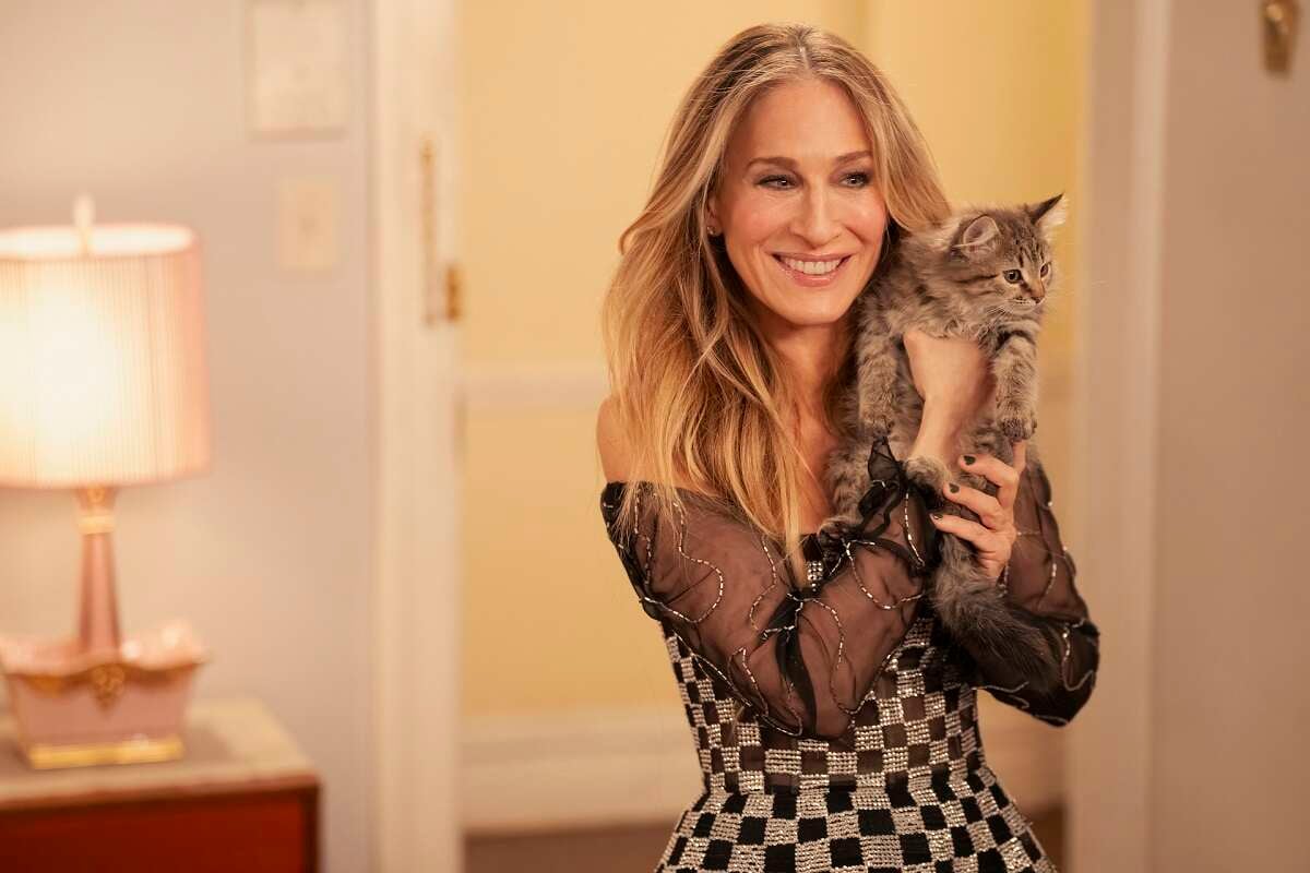 Sarah Jessica Parker as Carrie Bradshaw holds a kitten in an episode of 'And Just Like That...'