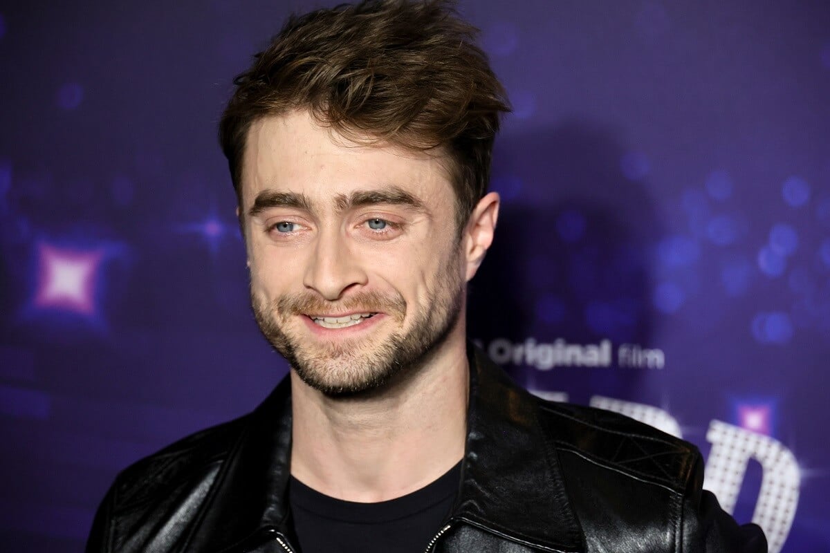 Daniel Radcliffe posing in a picture while wearing a black jacket at the premiere of 'Weird: The Al Yankovic Story'.