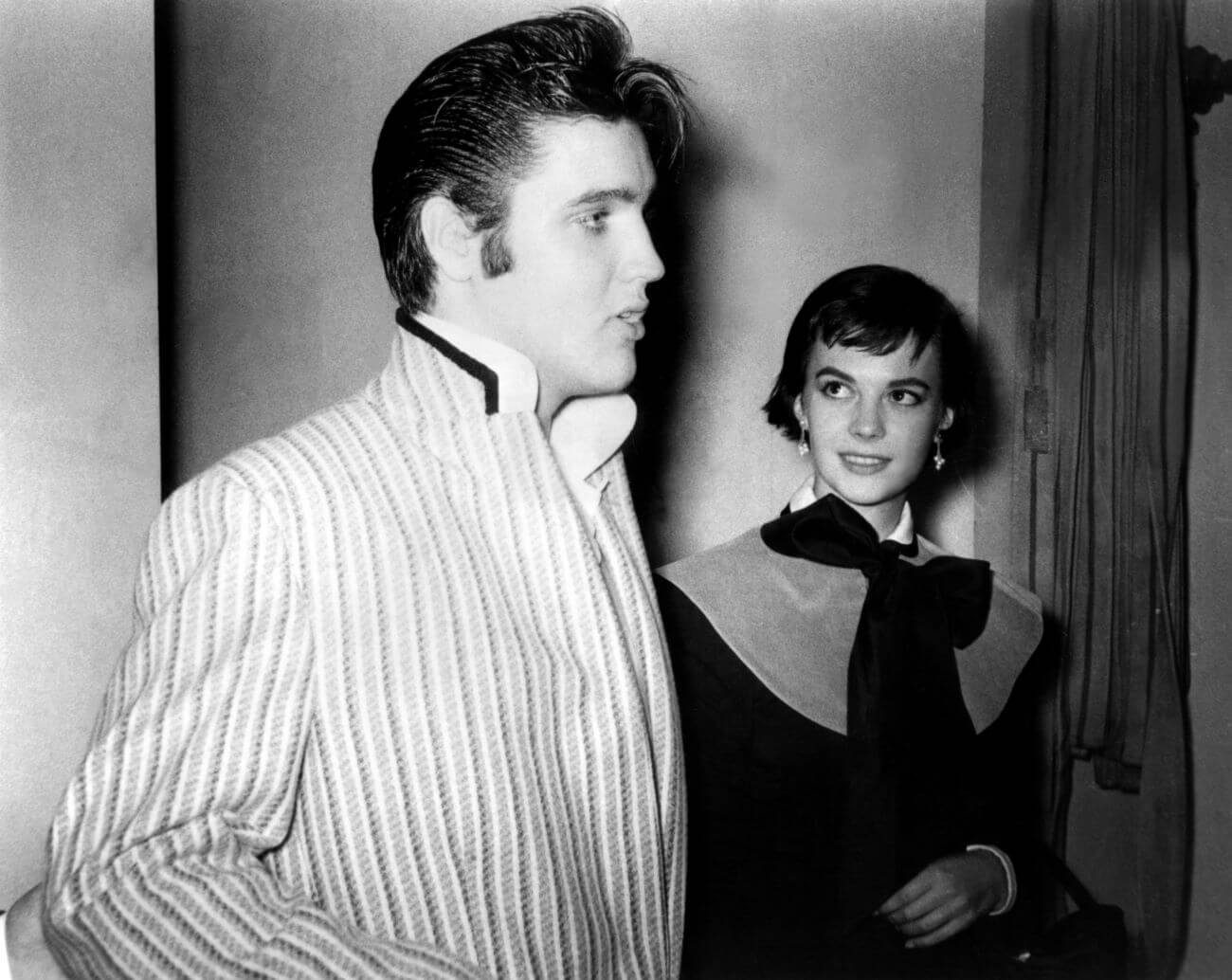 A black and white picture of Elvis standing in side profile and Natalie Wood looking up at him.