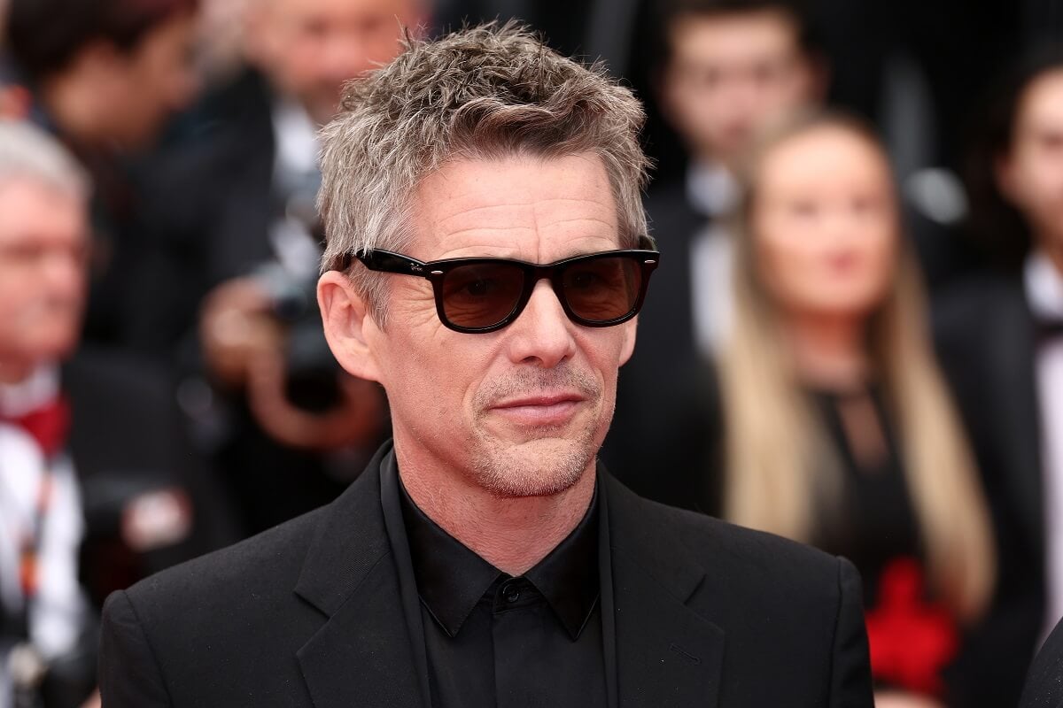 Ethan Hawke posing for a picture while attending the red carpet premiere of "Monster" in a suit.