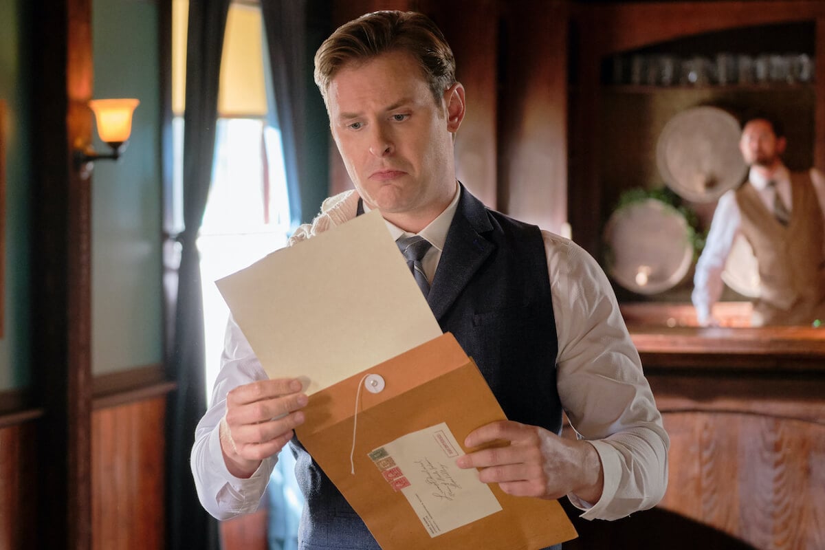 Hickam looking at a blank piece of paper in 'When Calls the Heart' Season 10
