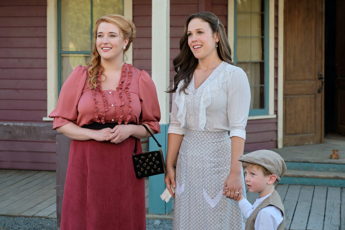 Julie standing next to Elizabeth, who is holding hands with Little Jack, in 'When Calls the Heart' Season 10