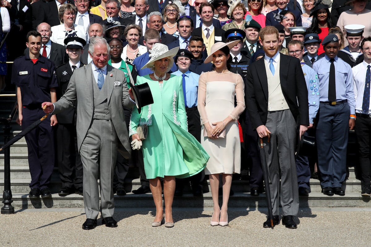 Prince Harry, who compared Meghan Markle to Princess Diana, which Princess Diana's siblings didn't understand, per Tom Bower's book, stands with King Charles III, Queen Camilla, and Meghan Markle.