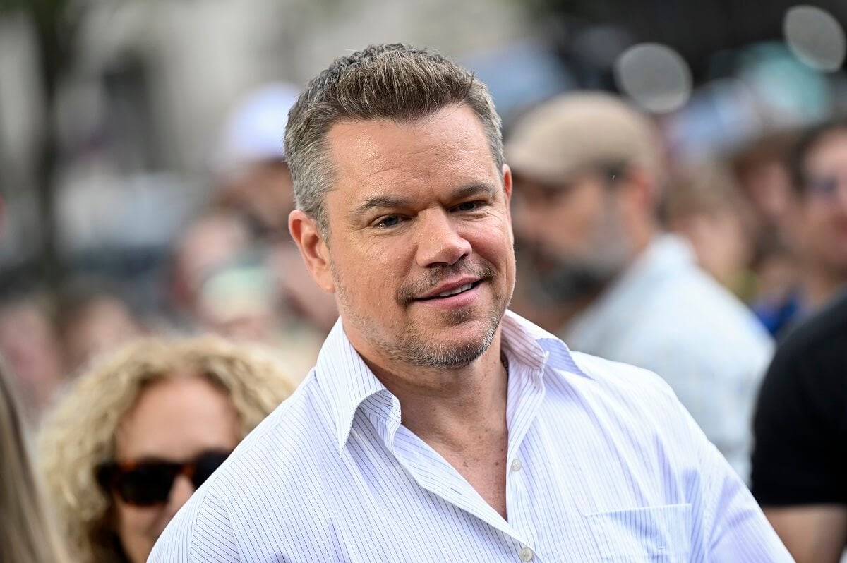 Matt Damon posing while wearing a button-up shirt at a photocall for 'Oppenheimer'.