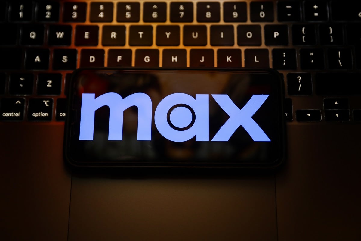 The Max logo is seen ona phone screen against a computer keyboard