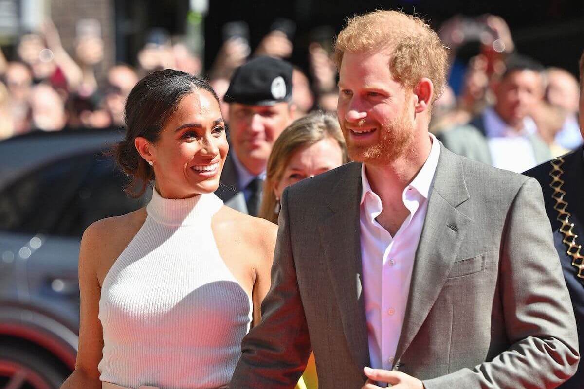 Meghan Markle and Prince Harry, who need to be 'better' at communicating their purpose, per a commentator, smile and hold hands