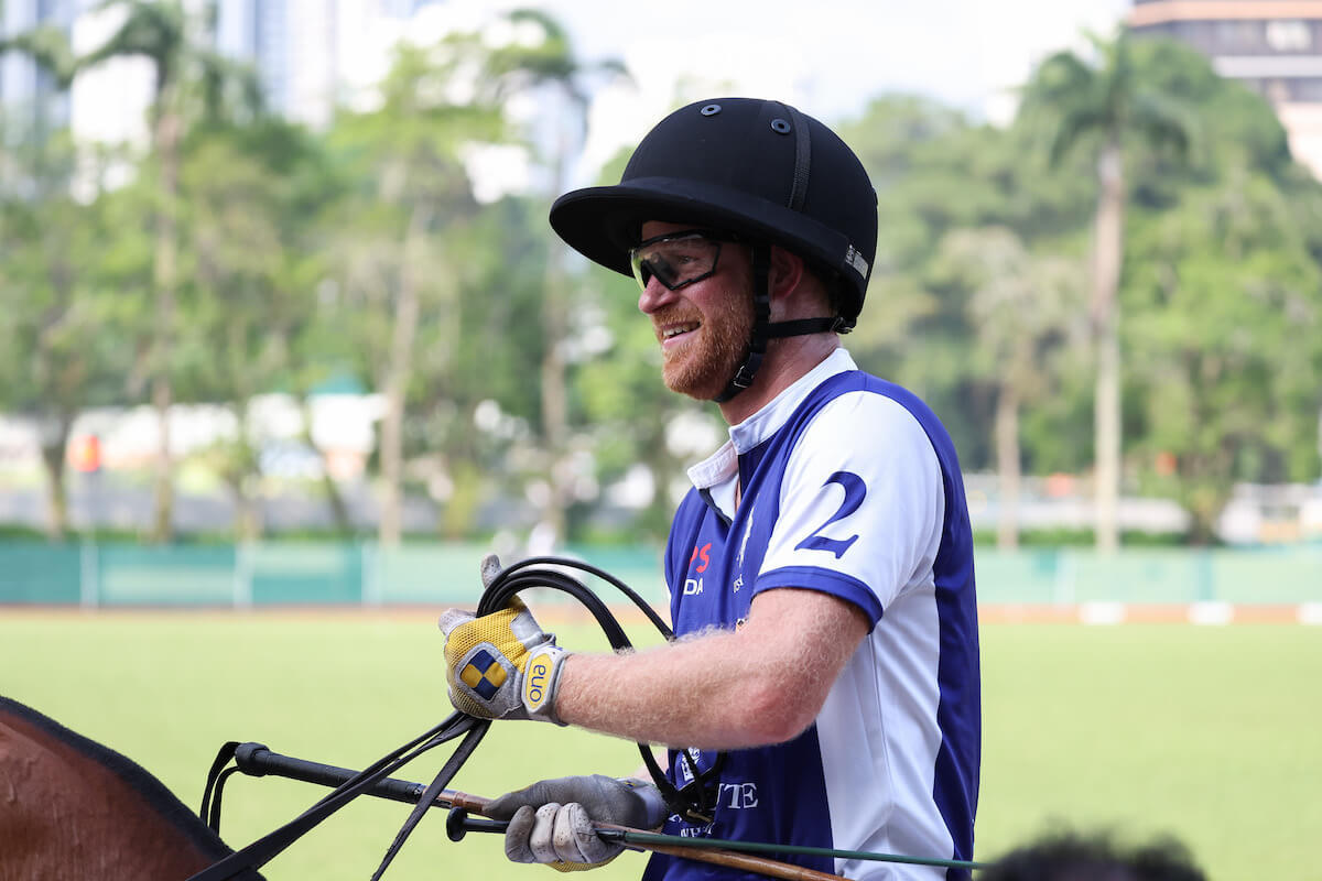 Prince Harry, who didn't have his 'royal status' at a Singapore polo match, smiles while riding a horse
