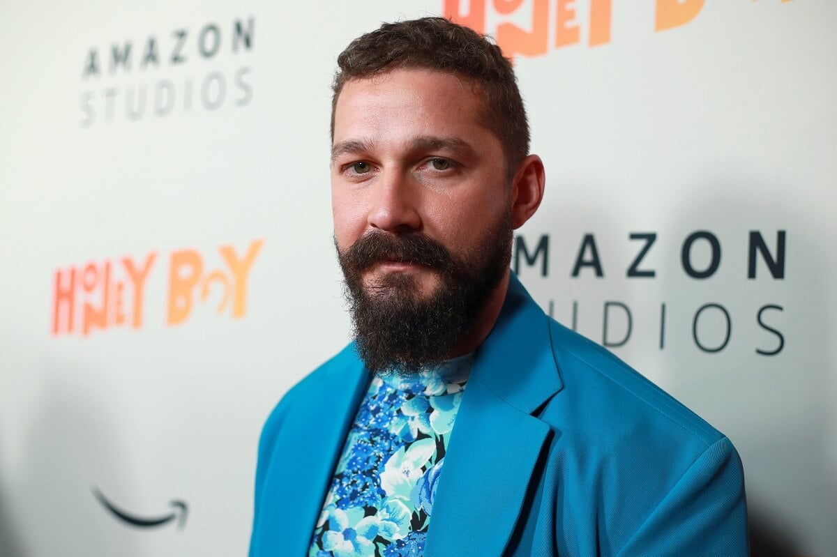 Shia LaBeouf posing in a blue suit at the premiere of 'Honey Boy'.