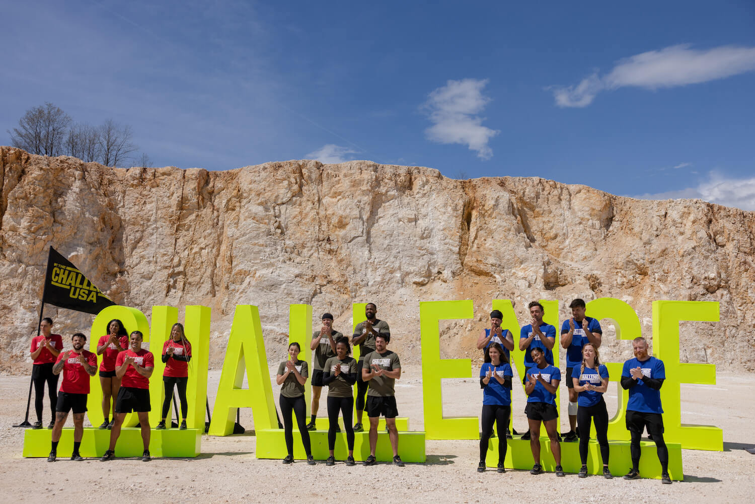 'The Challenge: USA' Season 2 Week 4 competitors standing in front of 'The Challenge' sign outside in their teams
