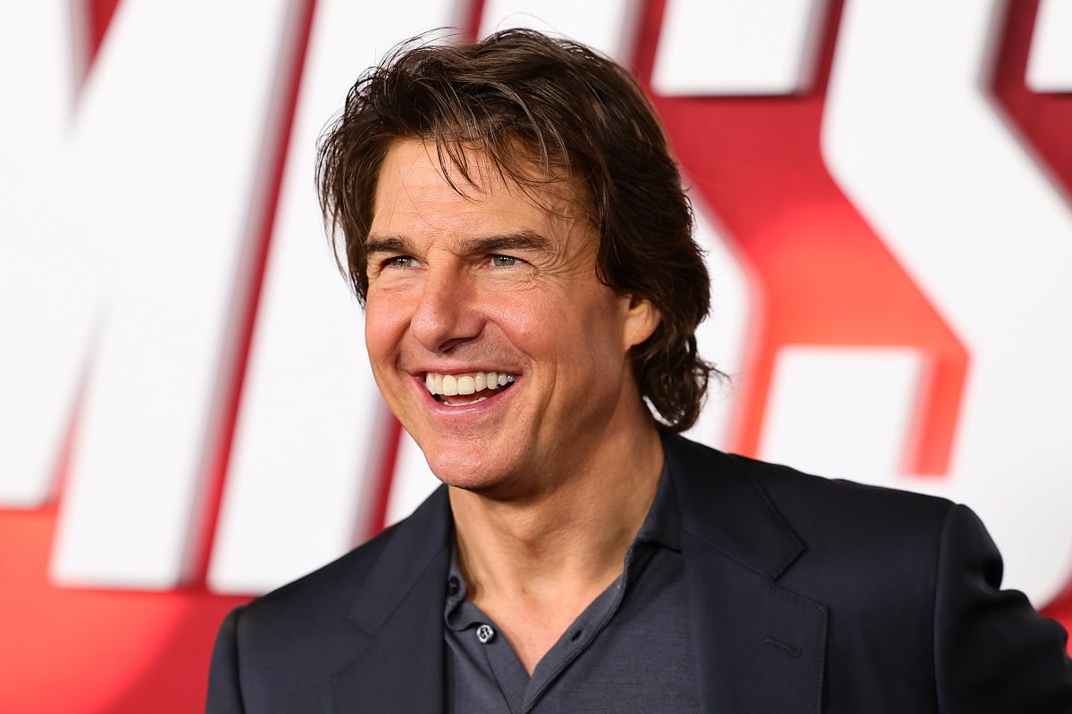 Tom Cruise smiling in a suit at the 'Mission Impossible' premiere.