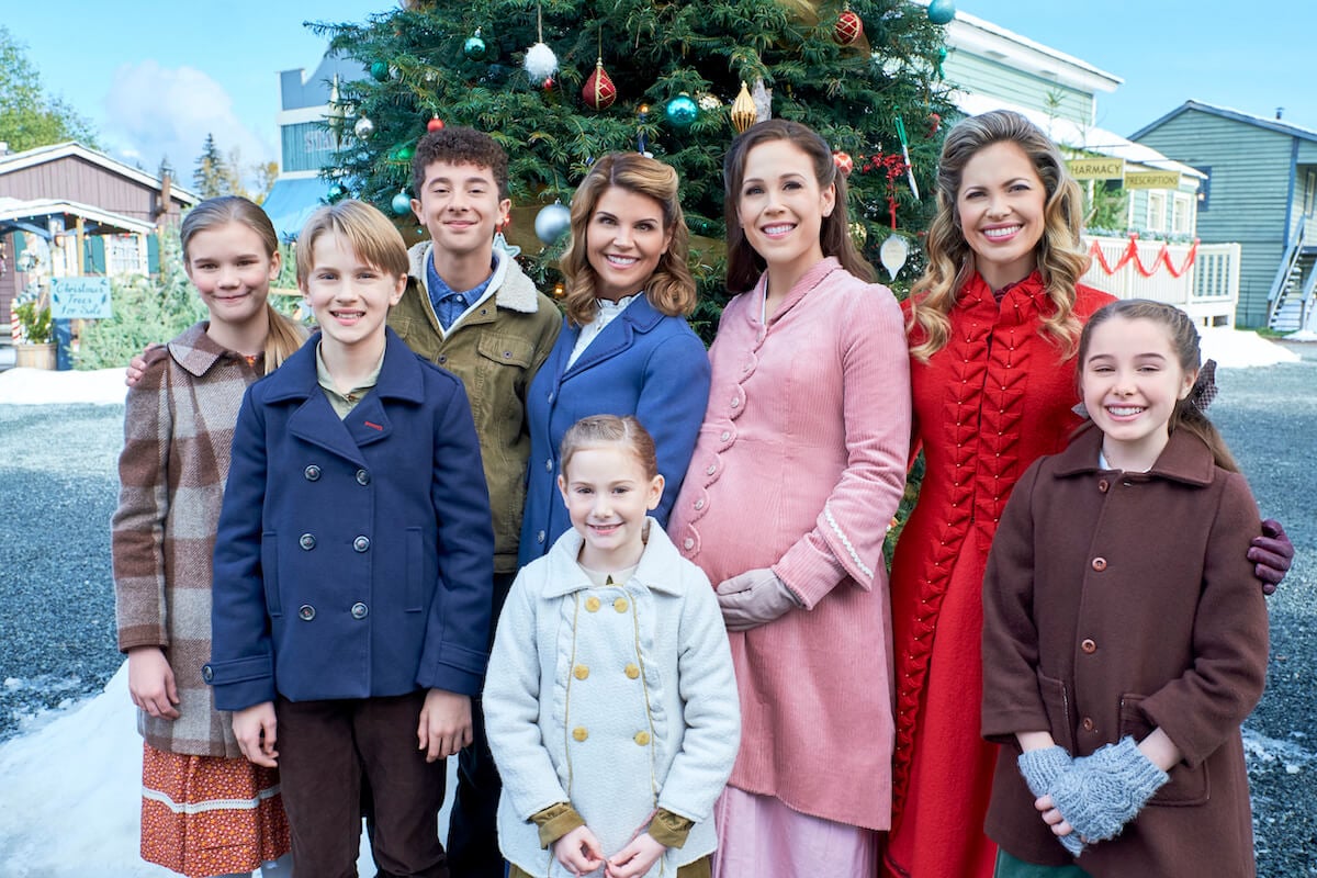 Elizabeth and Rosemary with the children of Hope Valley in front of a Christmas tree in a 'When Calls the Heart' Christmas special