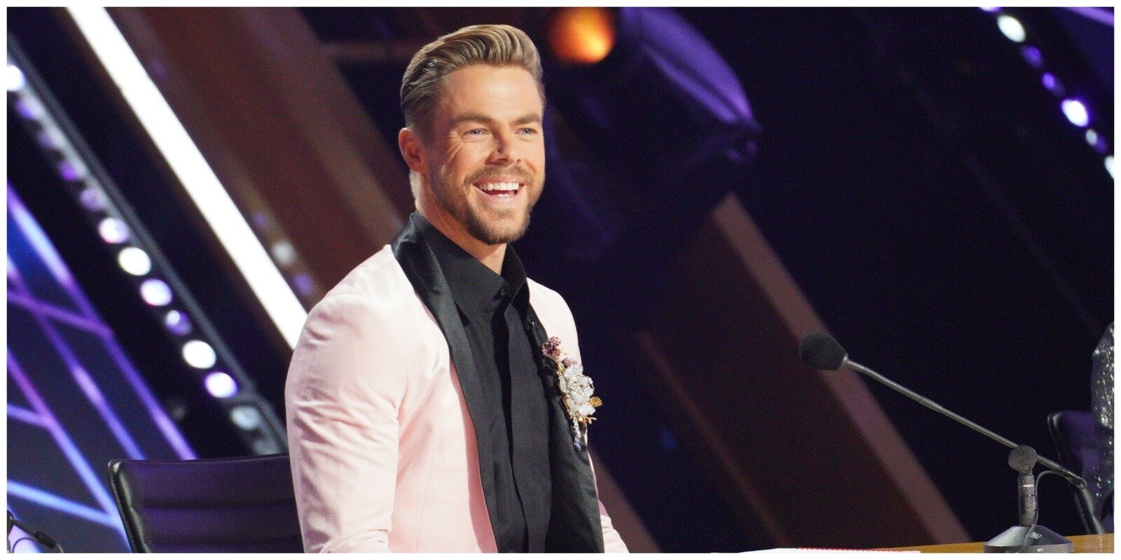 Derek Hough sits behind the judge's table during 'Dancing with the Stars' season 30.