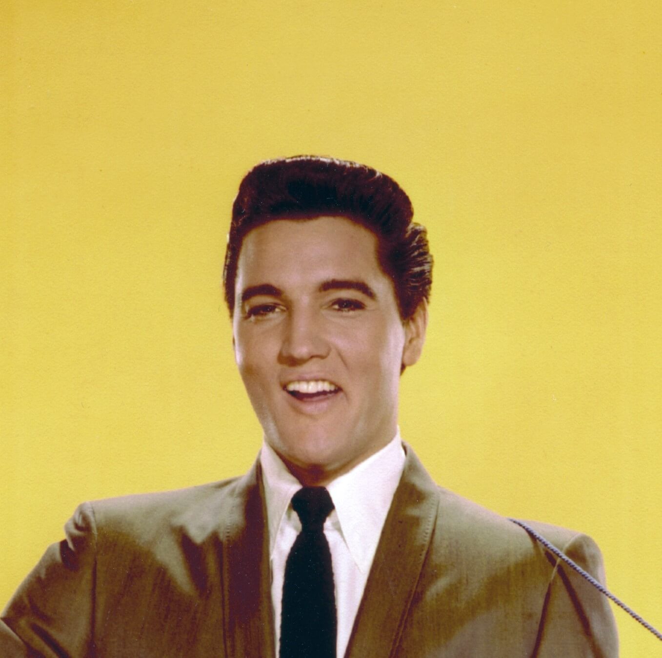 "Hound Dog" star Elvis Presley with a yellow backdrop