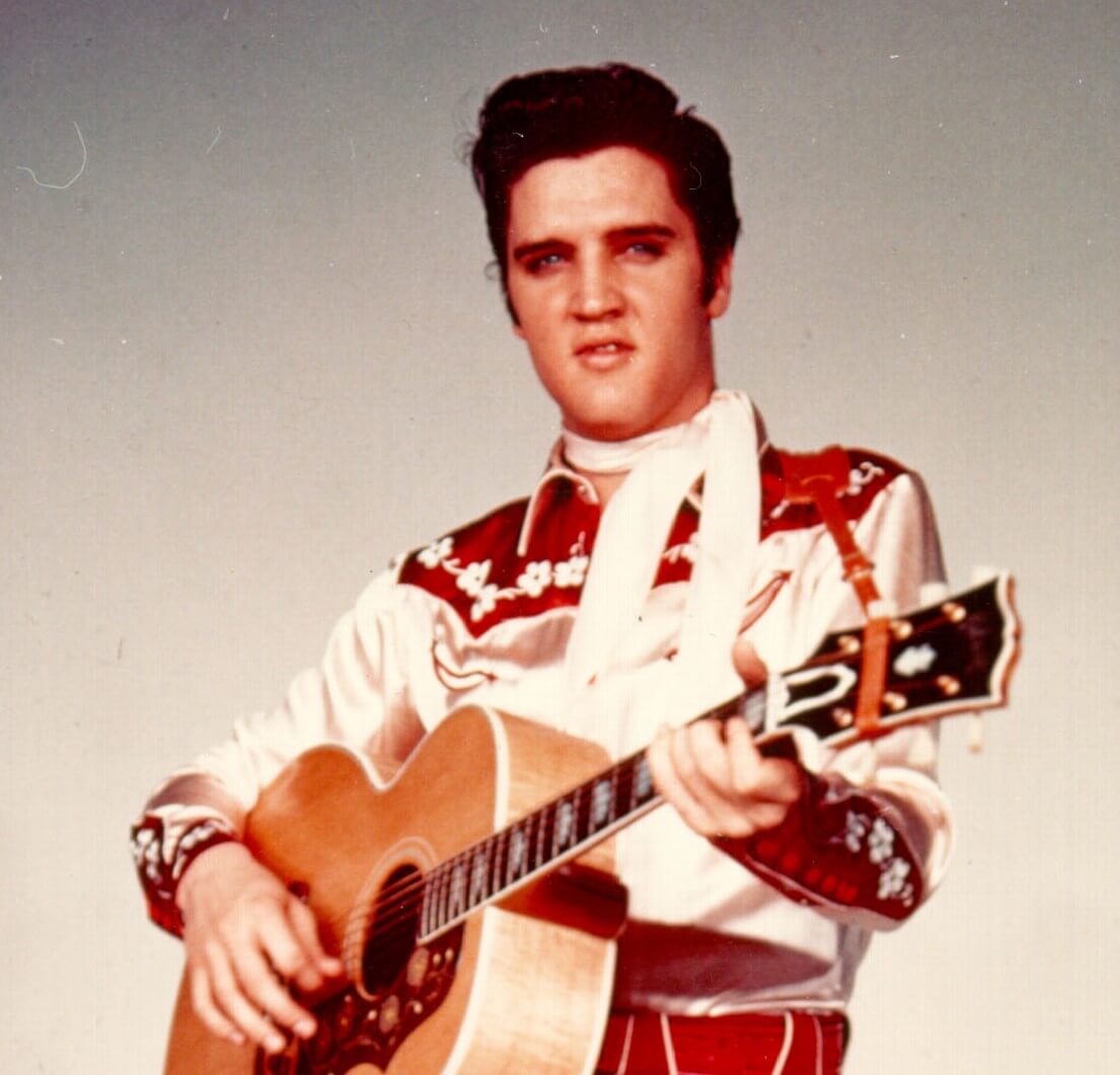 "Hard Headed Woman" singer Elvis Presley with a guitar
