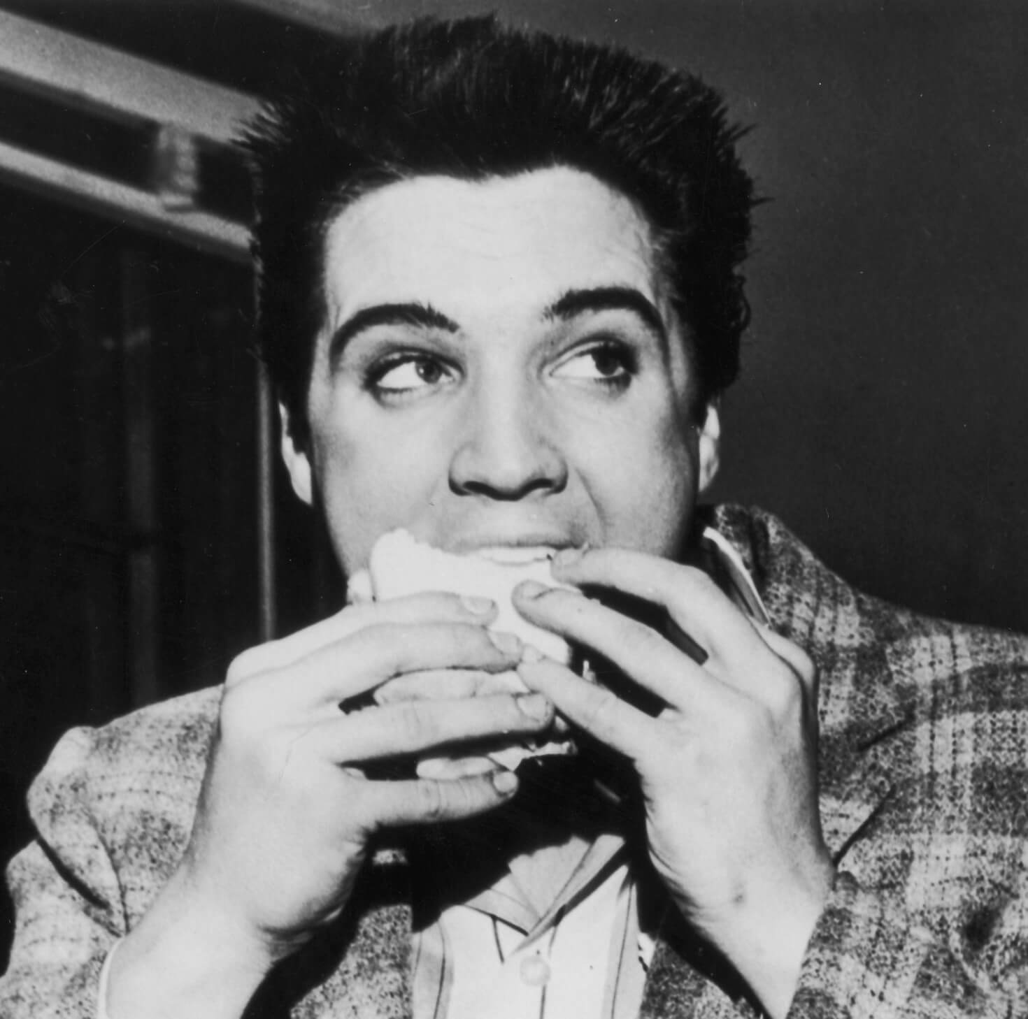"Jailhouse Rock" singer Elvis Presley eating a sandwich