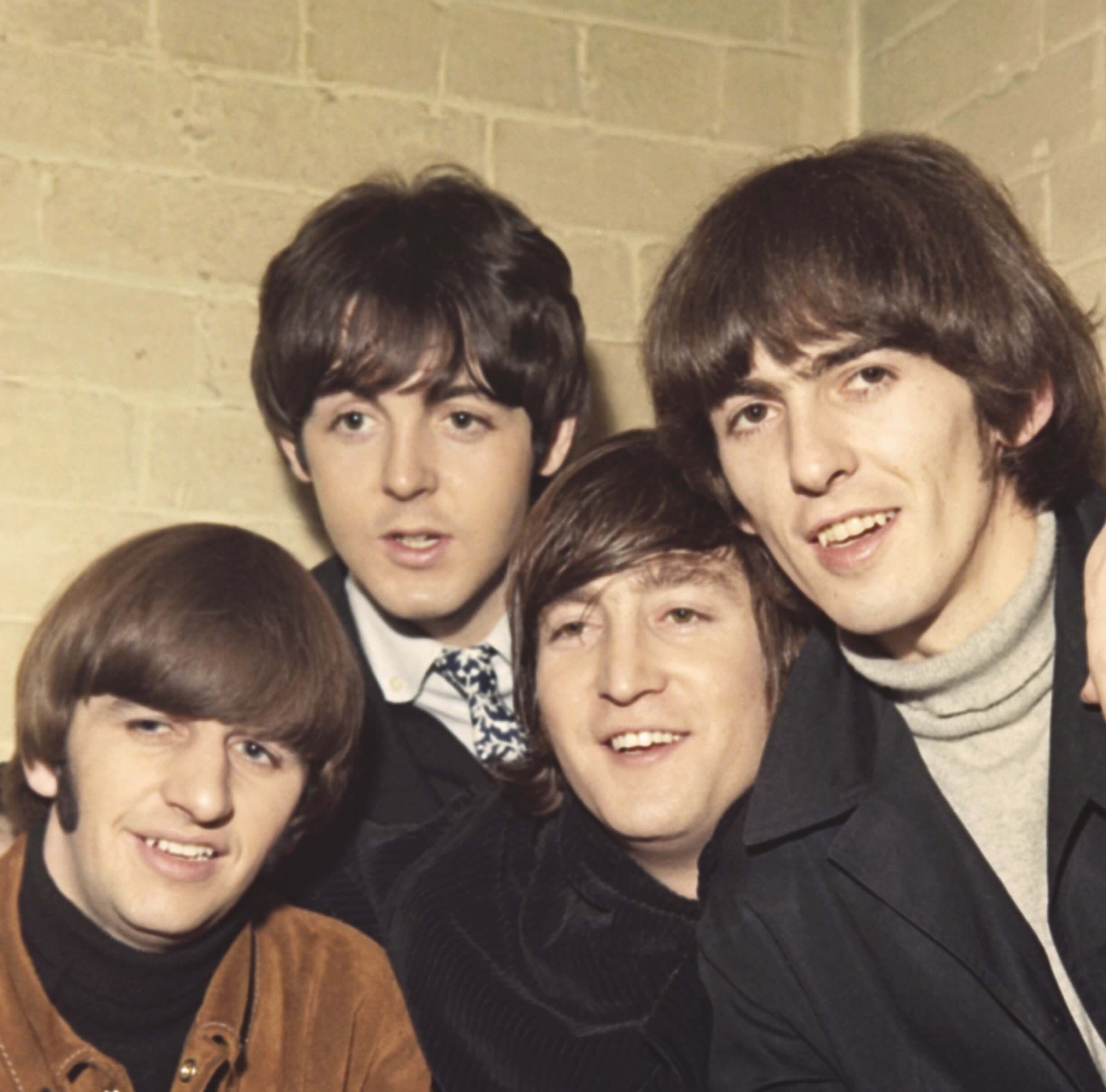 The Beatles, a band that inspired Oasis' Noel Gallagher, in front of a brick wall