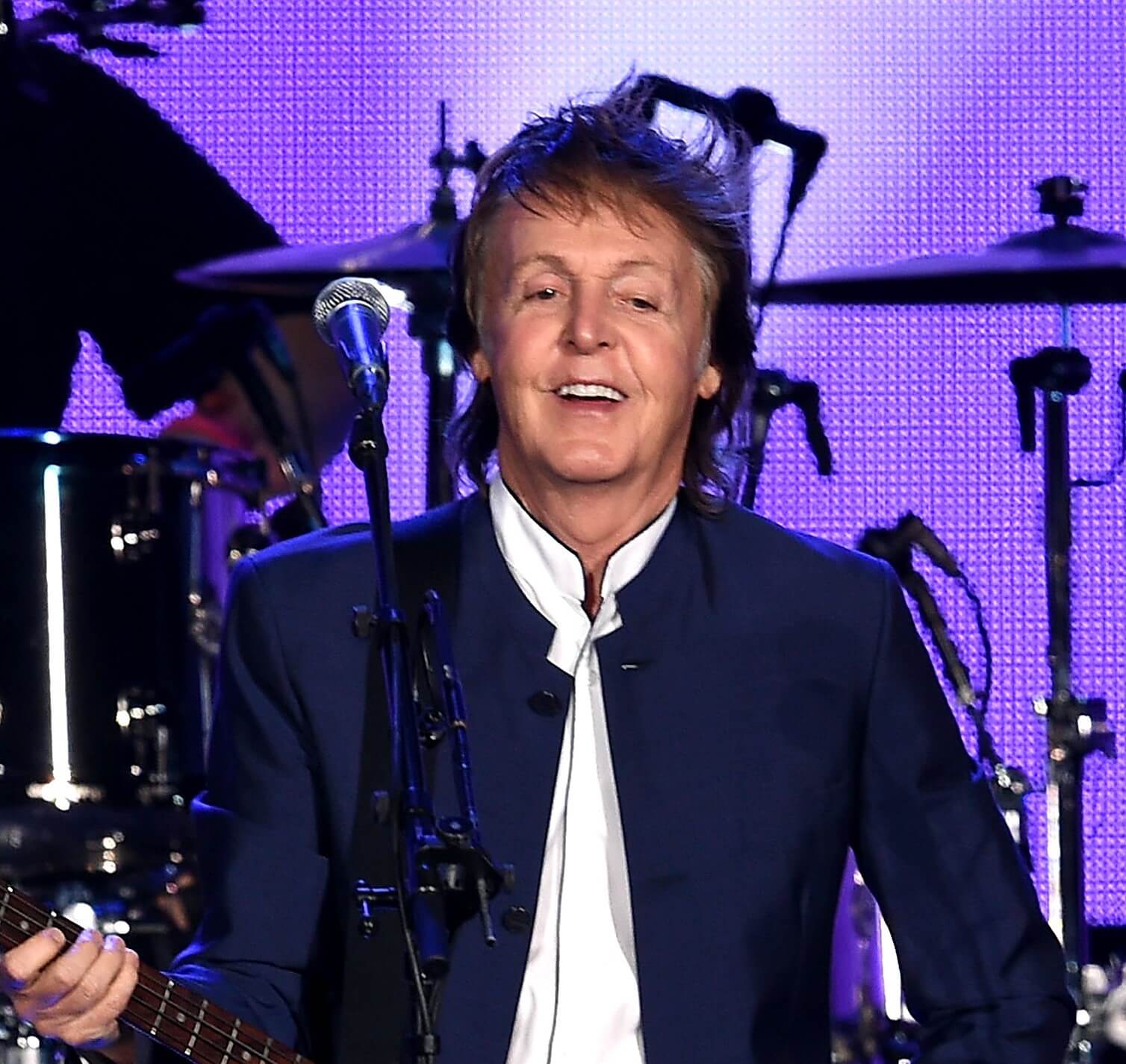 Paul McCartney singing songs in front of a drum set