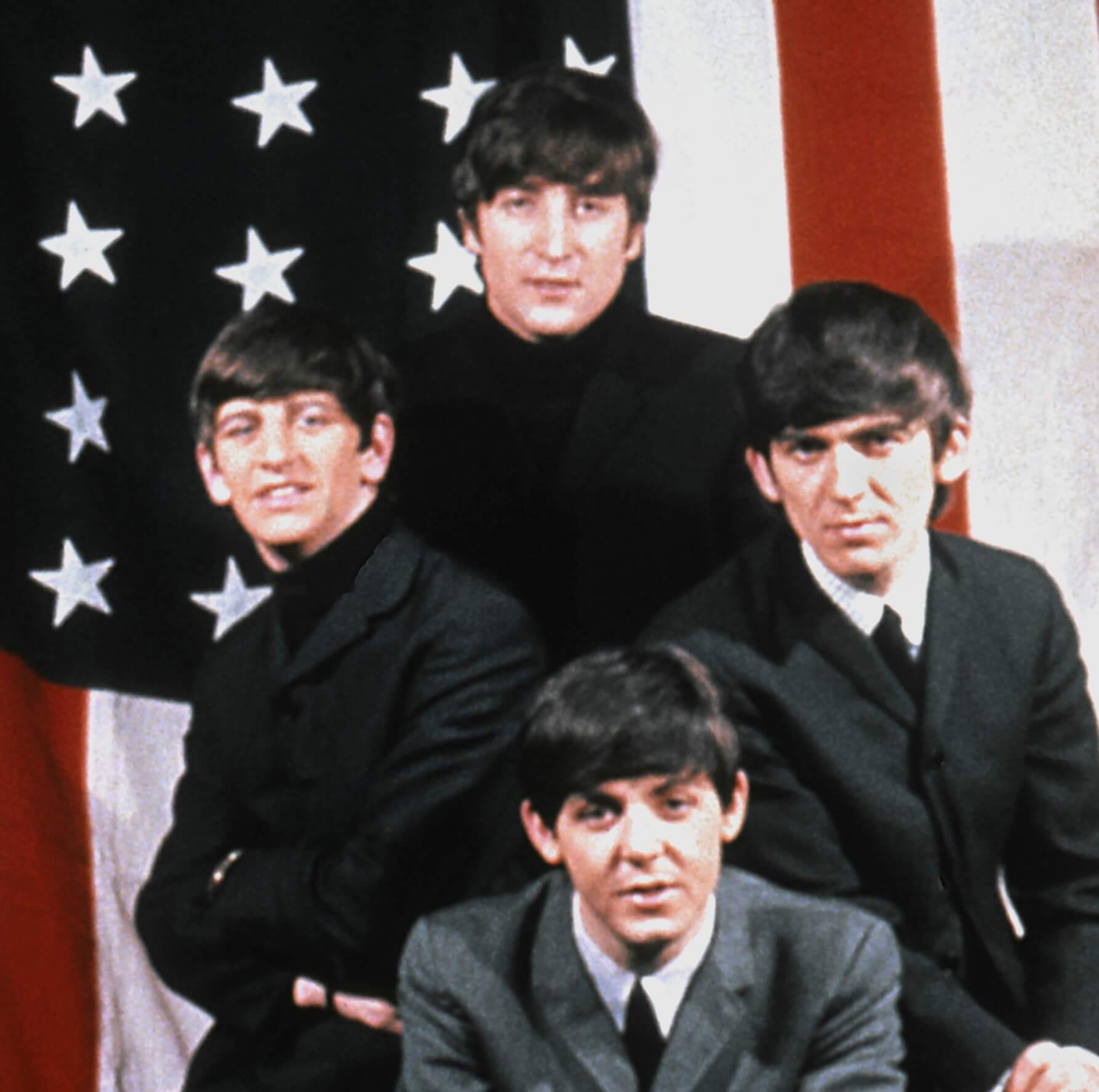 The Beatles in front of a flag