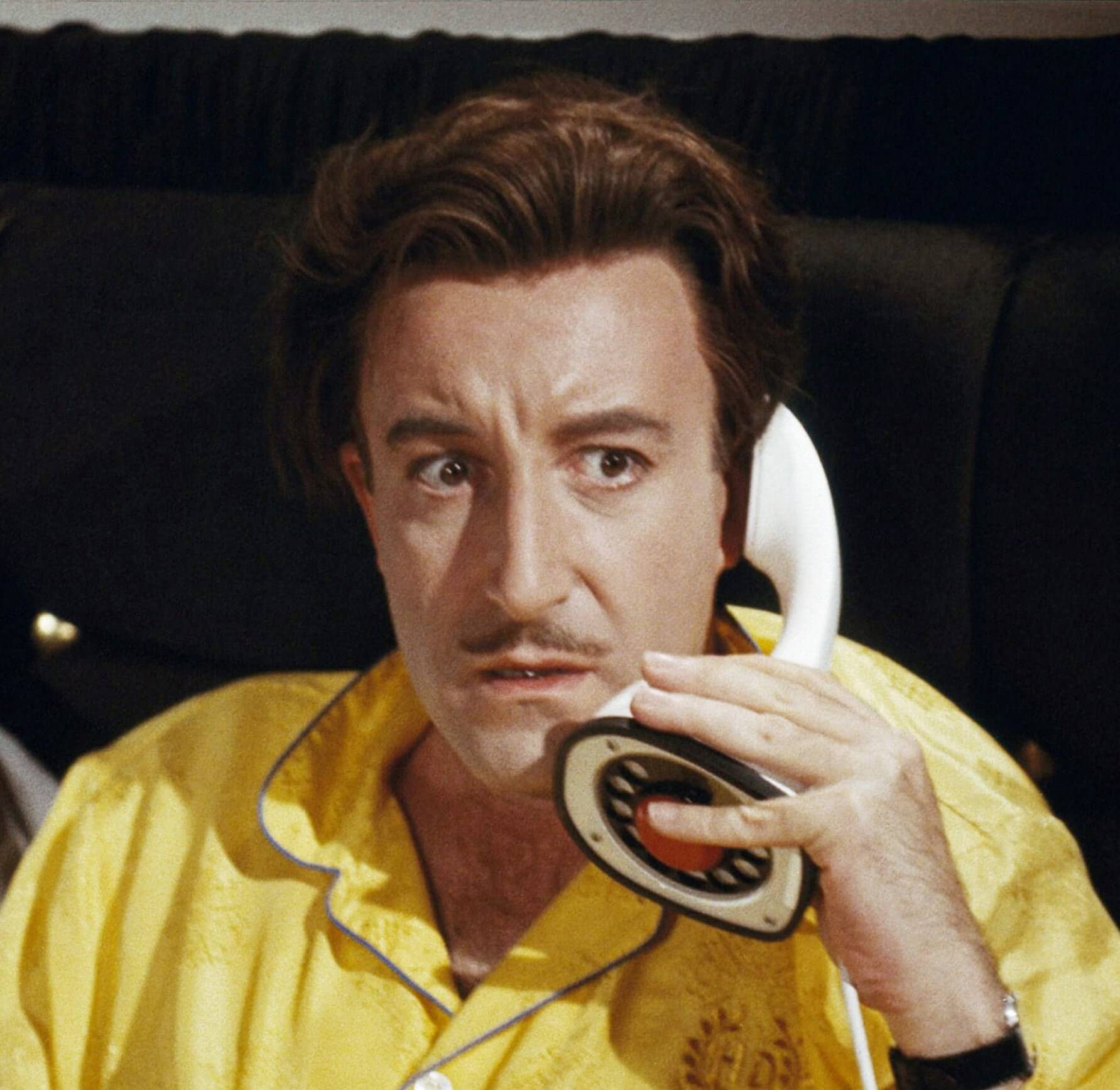 Peter Sellers holding a phone in the movie 'The World of Henry Orient'