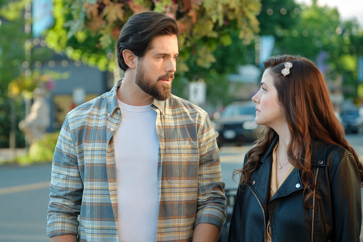 Chris McNally looking at Julie Gonzalo in the Hallmark Halloween movie '3 Bed, 2 Bath, 1 Ghost'