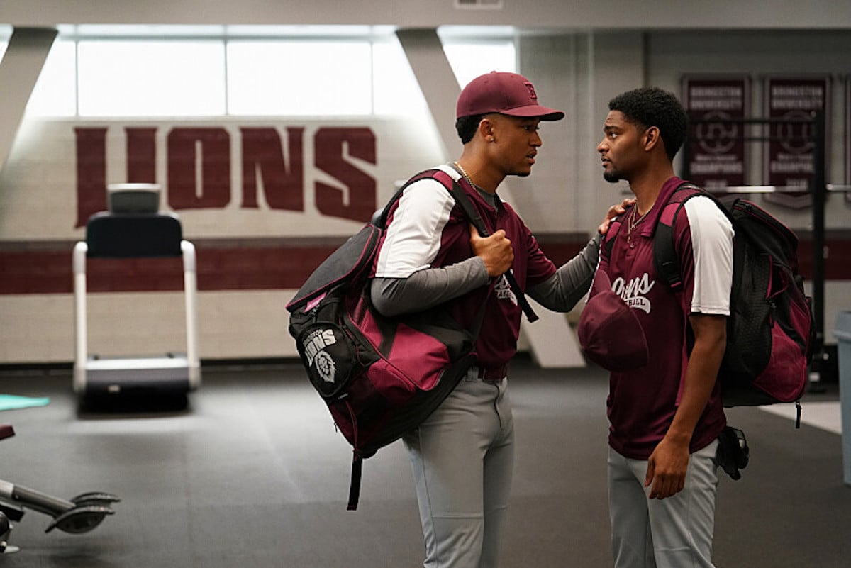 Two men in baseball uniforms talking to each other in 'All American: Homecoming' on The CW