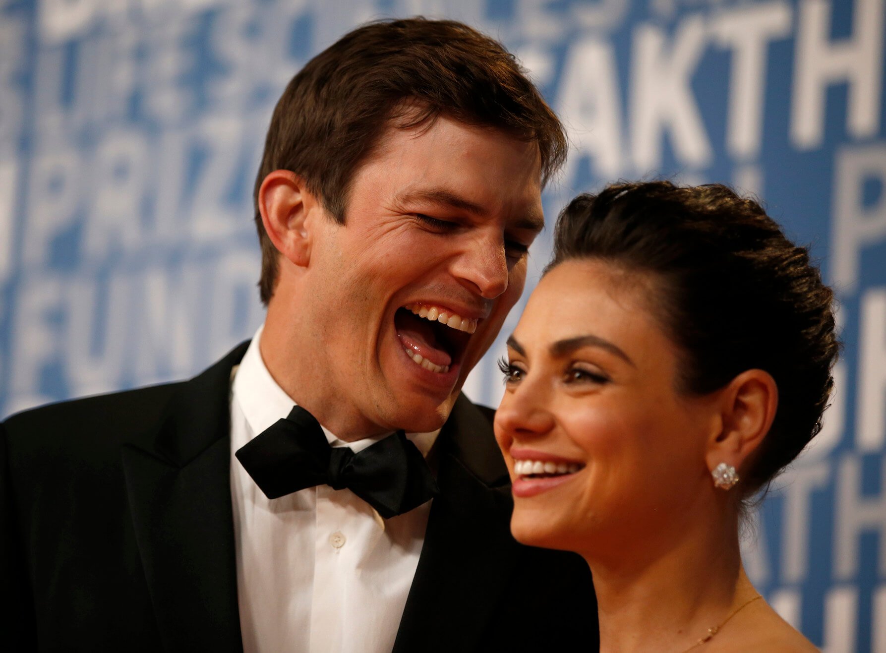 Ashton Kutcher making a funny face at Mila Kunis at an event. They are the parents of two children, Wyatt Isabelle and Dimitri Portwood