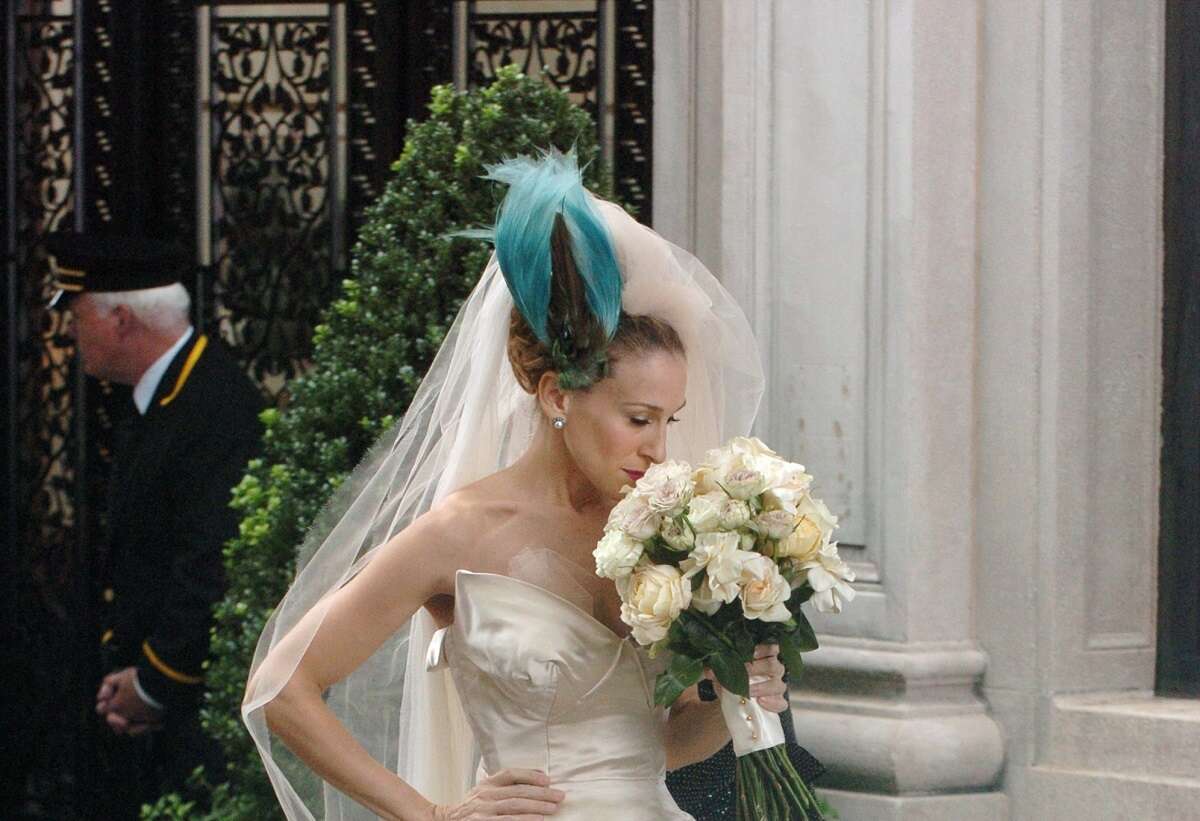 Sarah Jessica Parker as Carrie Bradshaw wears a bird headpiece and a Vivienne Westwood wedding gown while filming 'Sex and the City: The Movie'