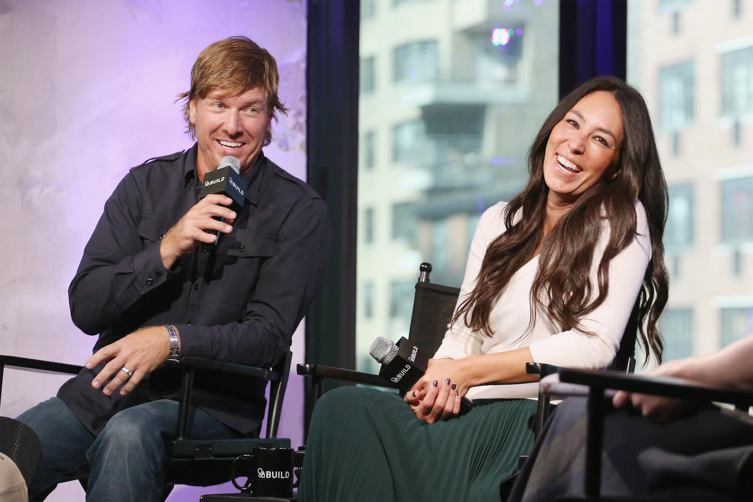 Chip and Joanna Gaines talking on stage and laughing