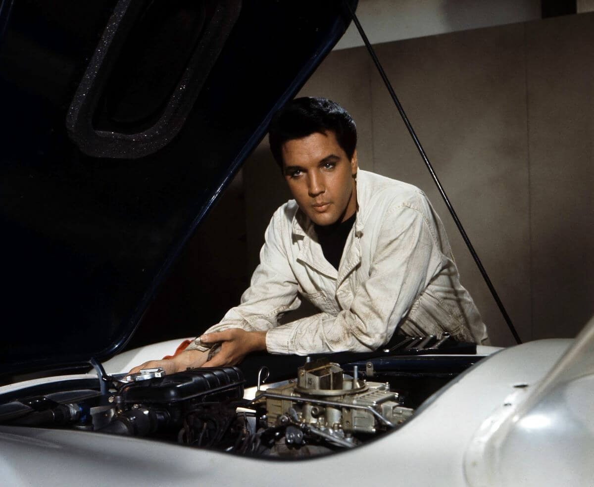 Elvis looks under the hood of a car in the film 'Speedway.'
