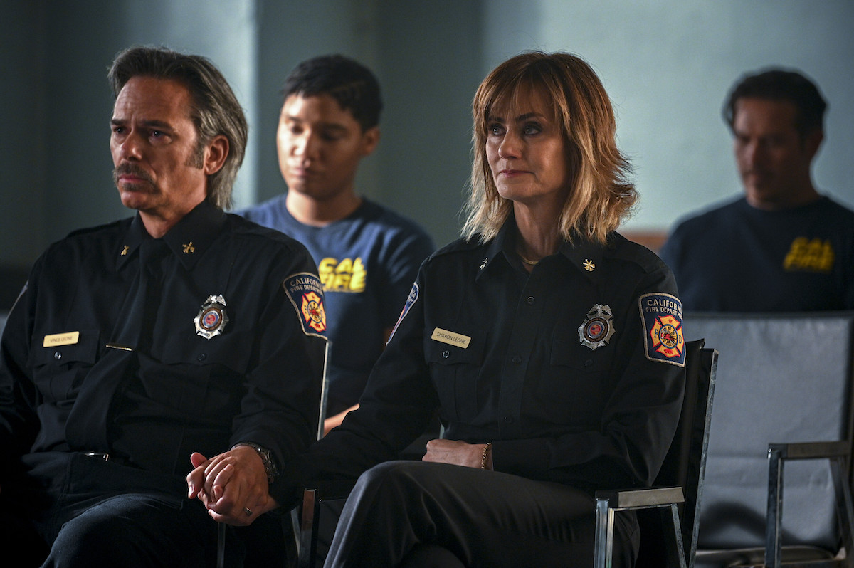 Billy Burke and Diane Far in uniform and holding hands in the 'Fire Country' Season 1 finale episode